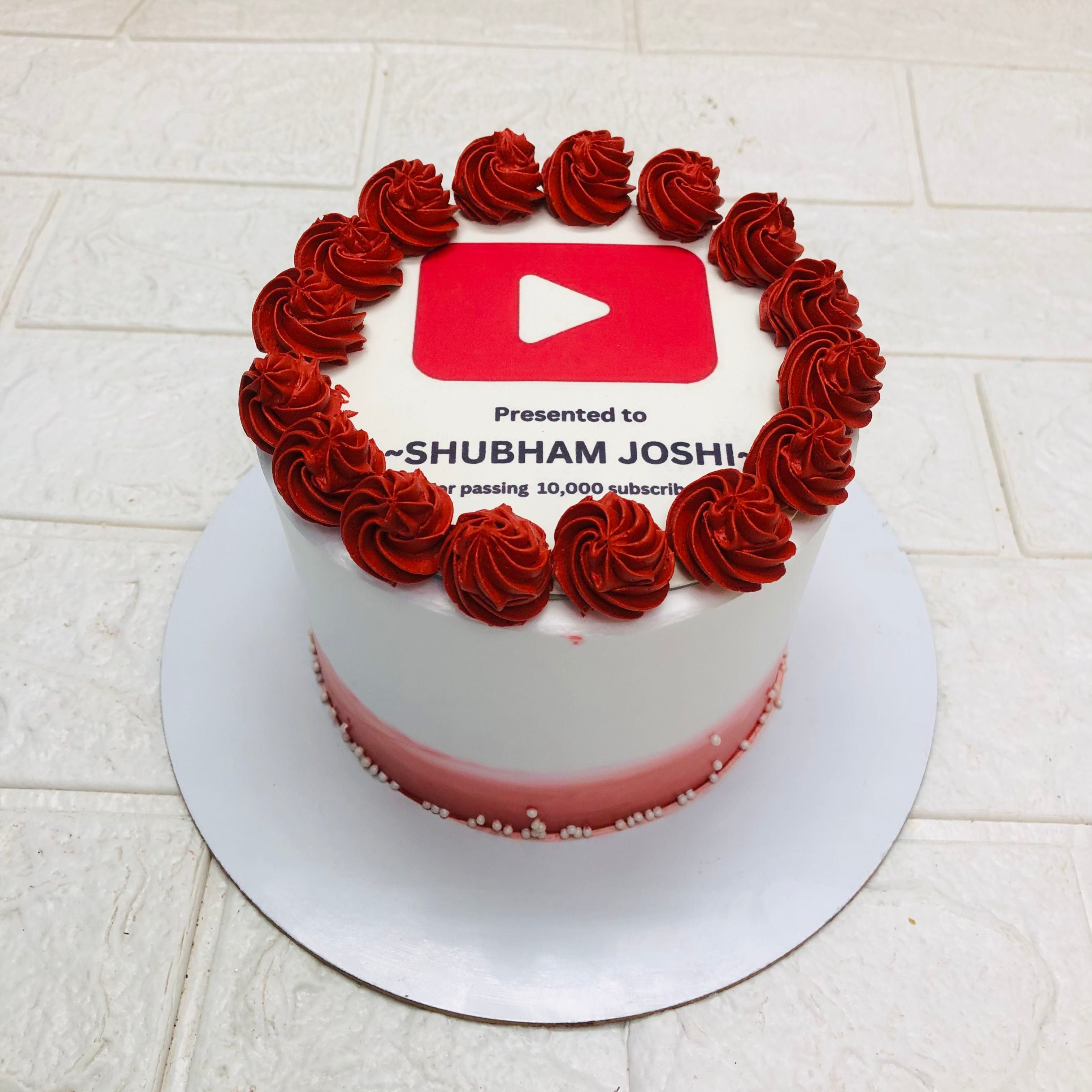 A cake decorated with the YouTube logo, showcasing a vibrant design and inviting appearance.