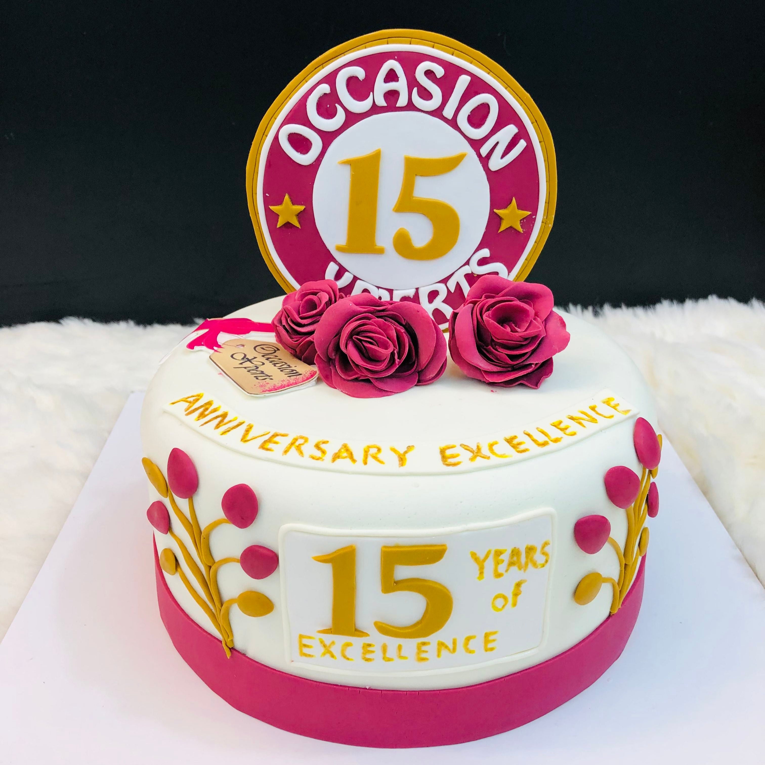 A beautifully decorated cake celebrating a 15th anniversary, featuring elegant designs and the number 15 prominently displayed.
