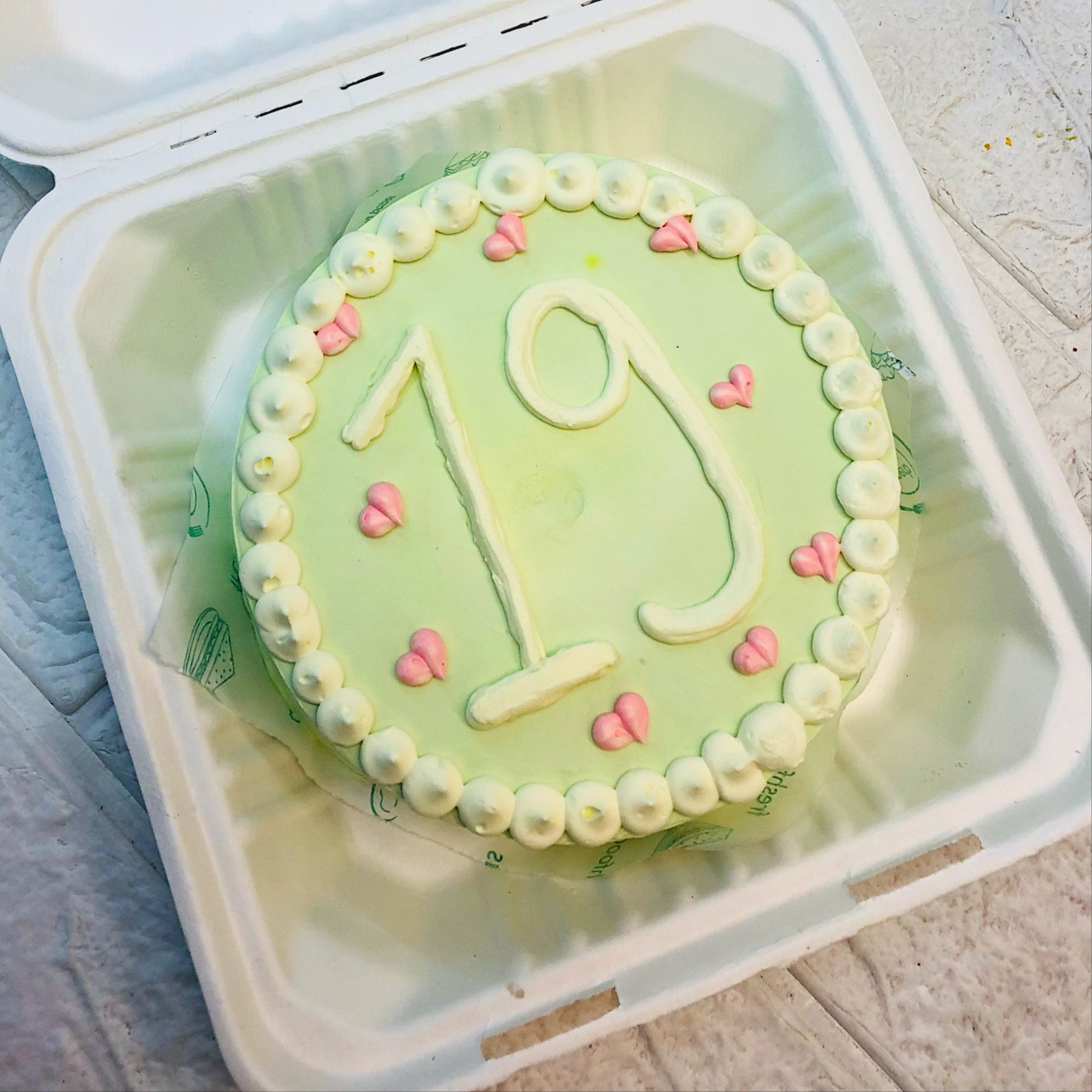 A cake in a box featuring the number 19 prominently displayed on top.
