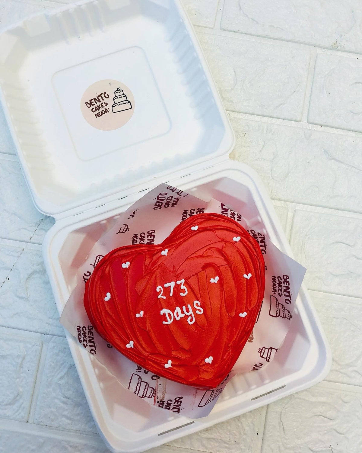 A dark red wavy design cake with pretty white hearts on it.