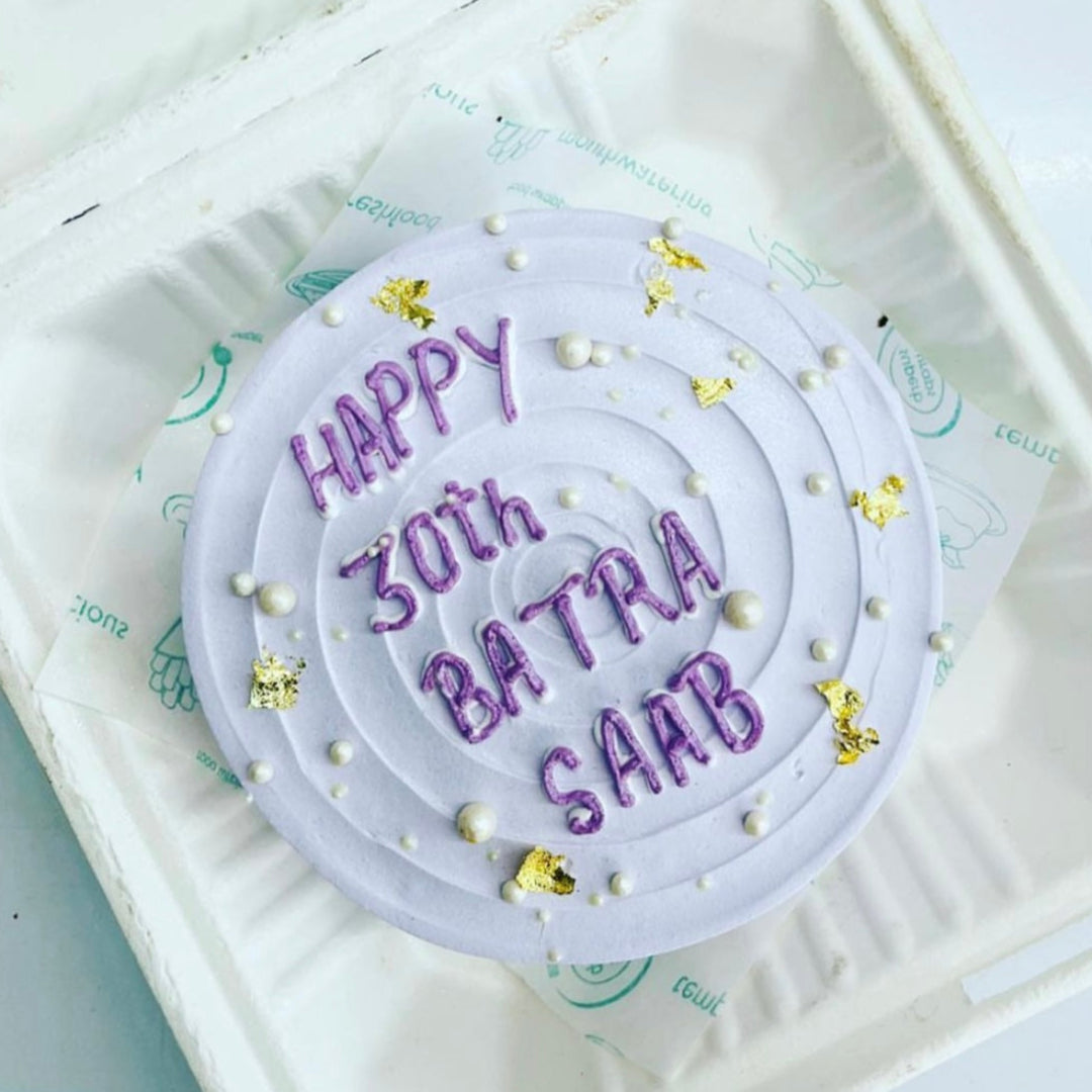 A festive birthday cake inside a soft foam container, featuring the inscription "Happy 30th Birthday" in vibrant letters.