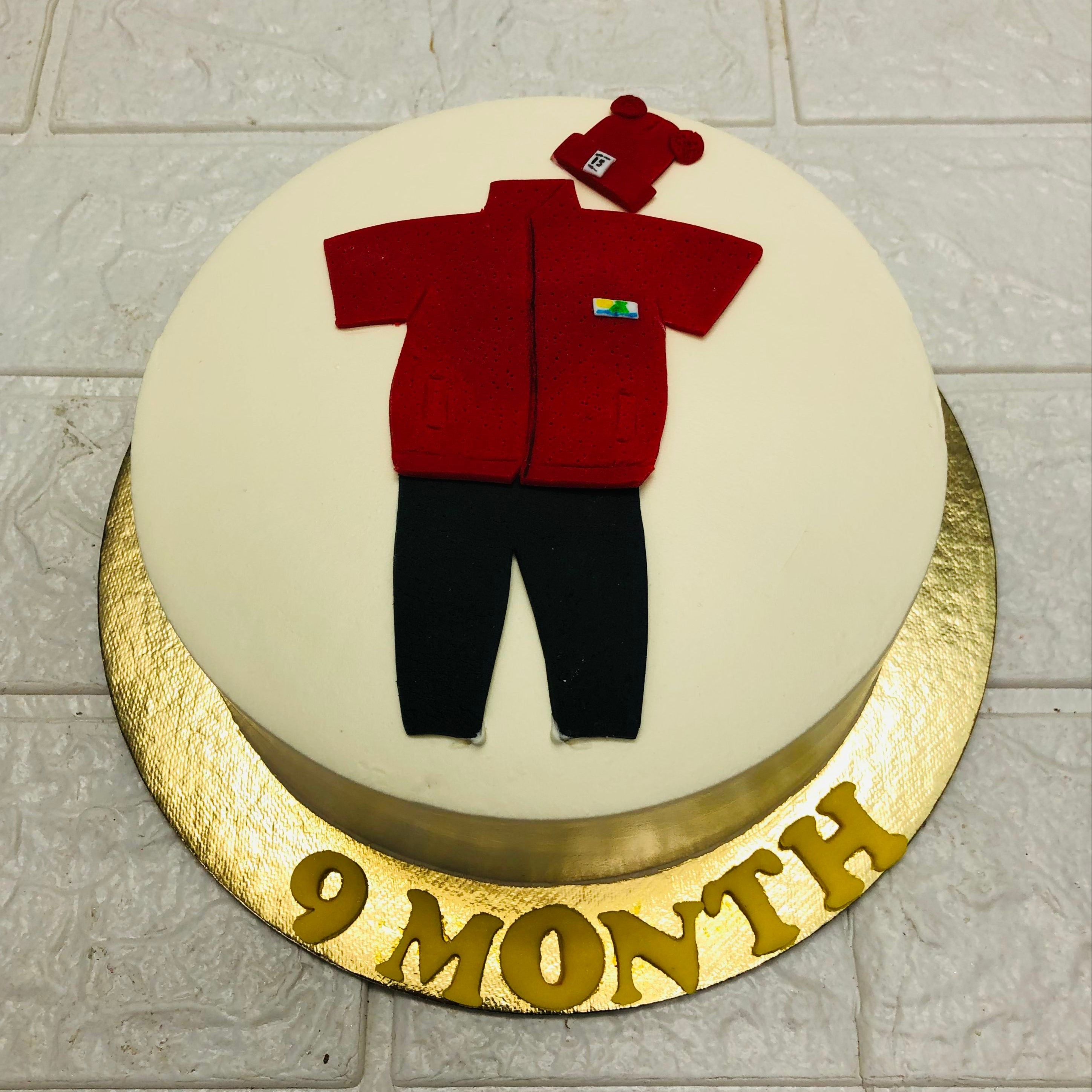 A whimsical cake adorned with a cute baby outfit, perfect for a baby shower celebration.