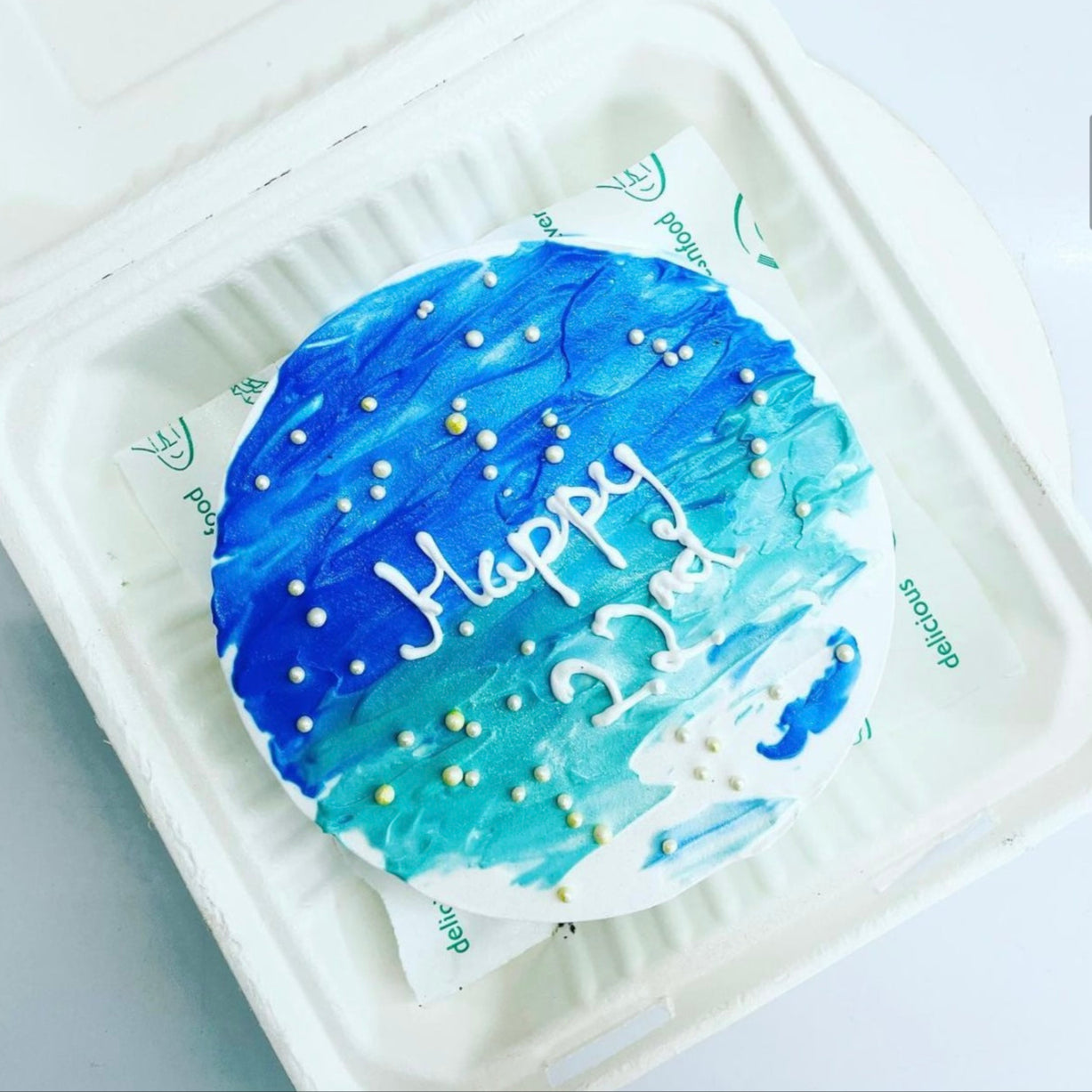 A birthday cake displayed in a soft foam container, adorned with a joyful "Happy 22nd Birthday" inscription. 