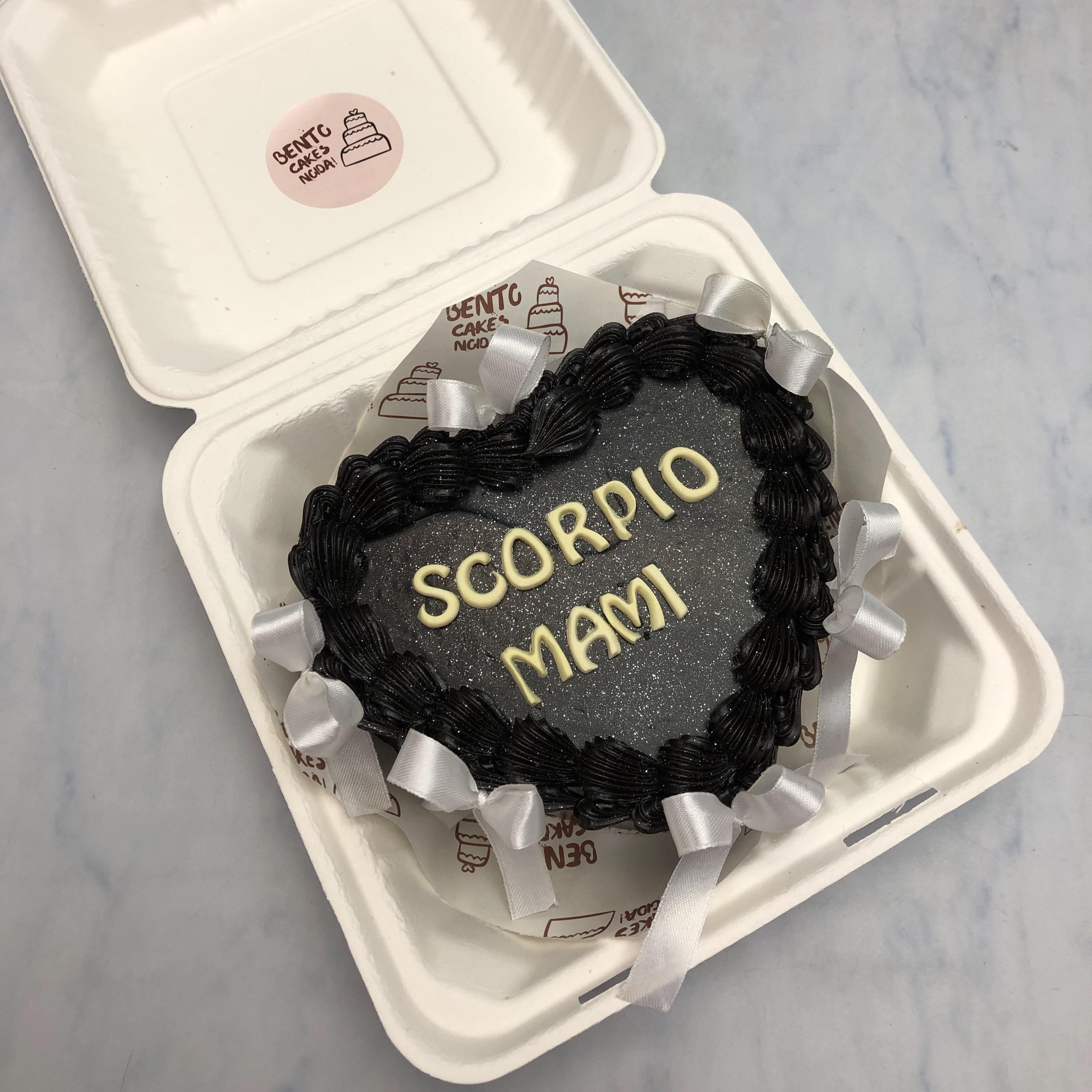 A Aesthetic Black heart shape bento cake with white bows.