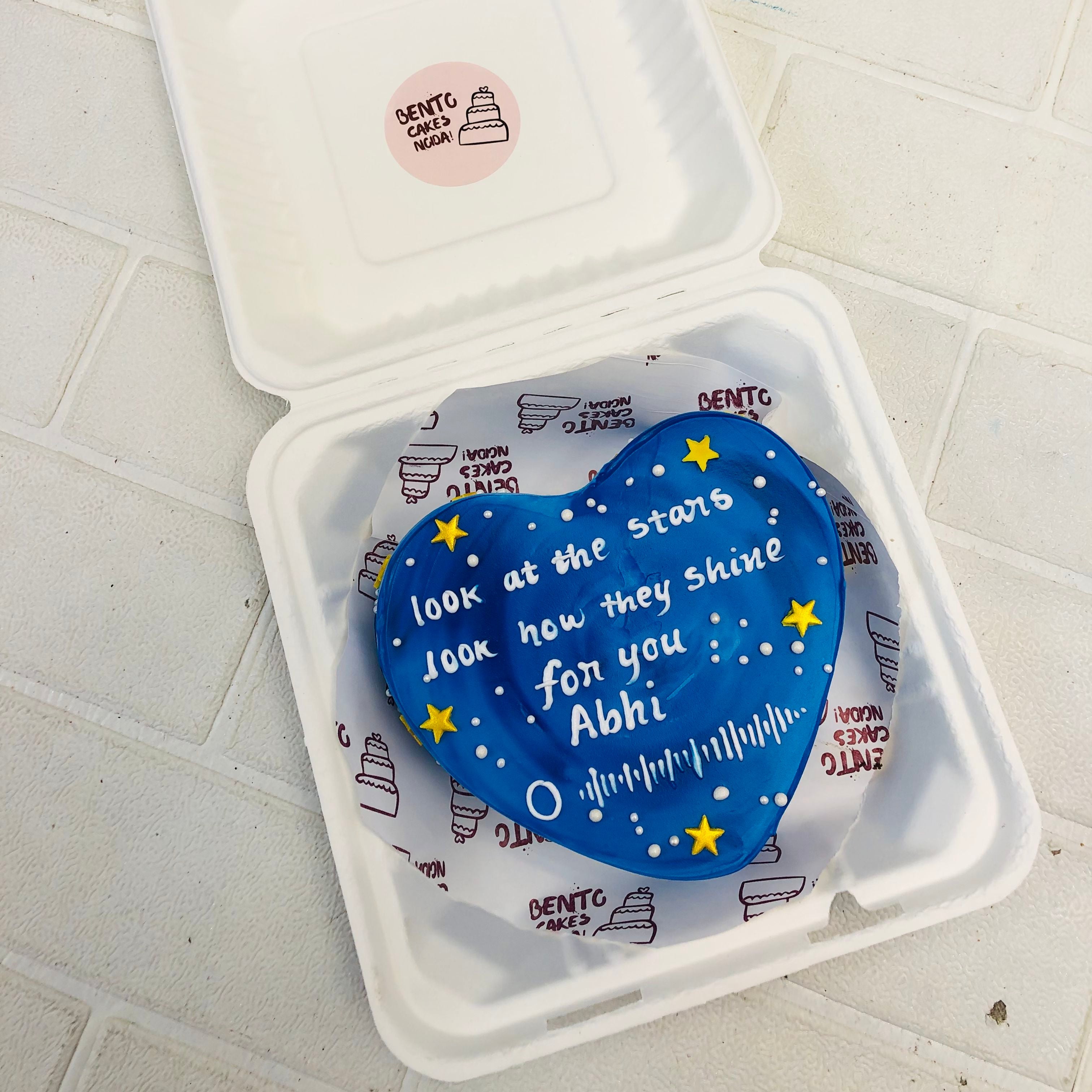 A dark blue mix eart shape cake with golden stars and a beautiful text written on it.