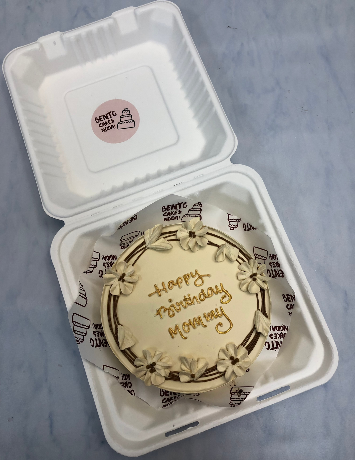 A coffee color bento cake is decorated with aesthetic brown floral design  for mothers birthday.