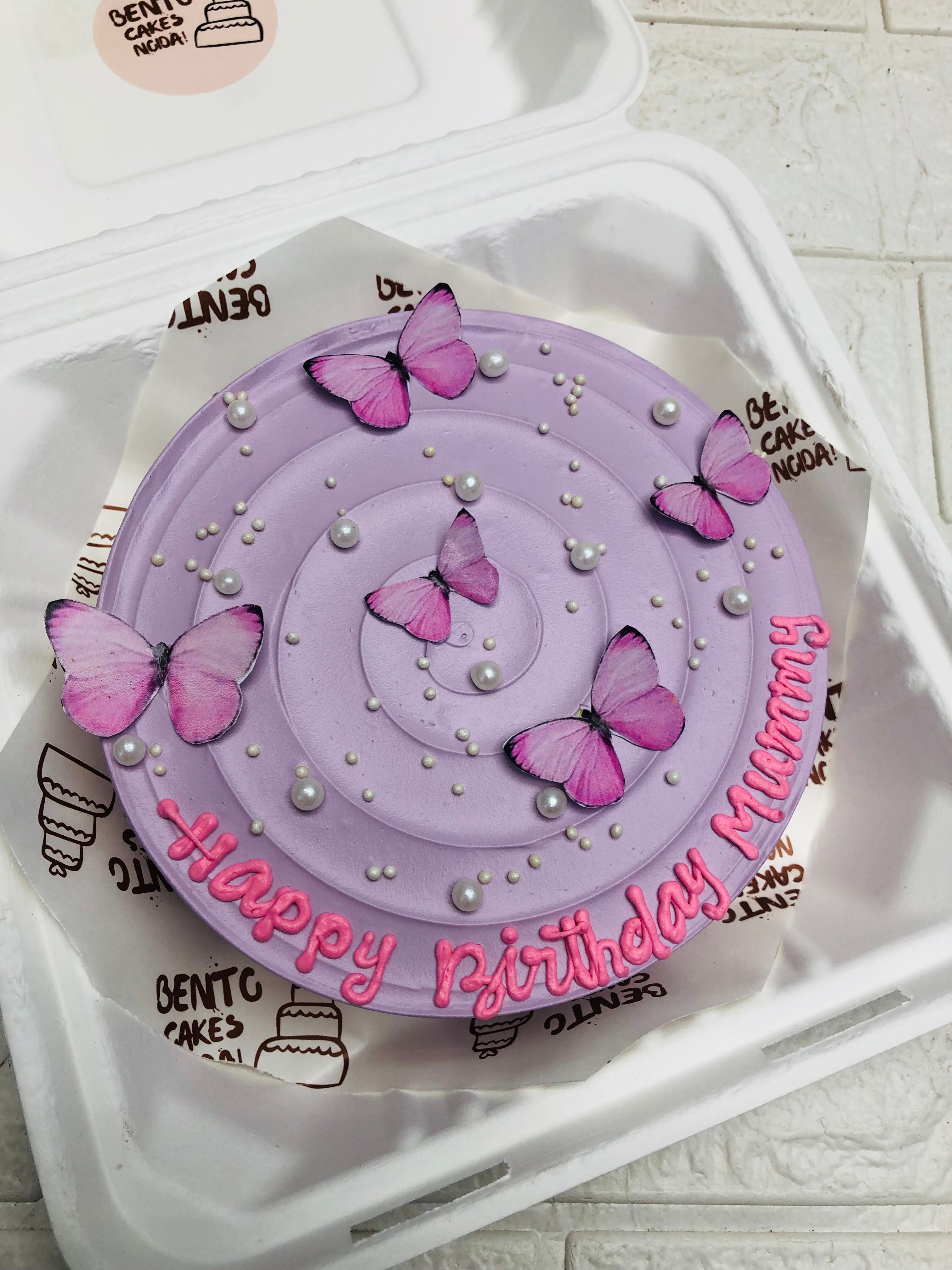 A elegant purple bento cake with purple butterflies for moms birthday.