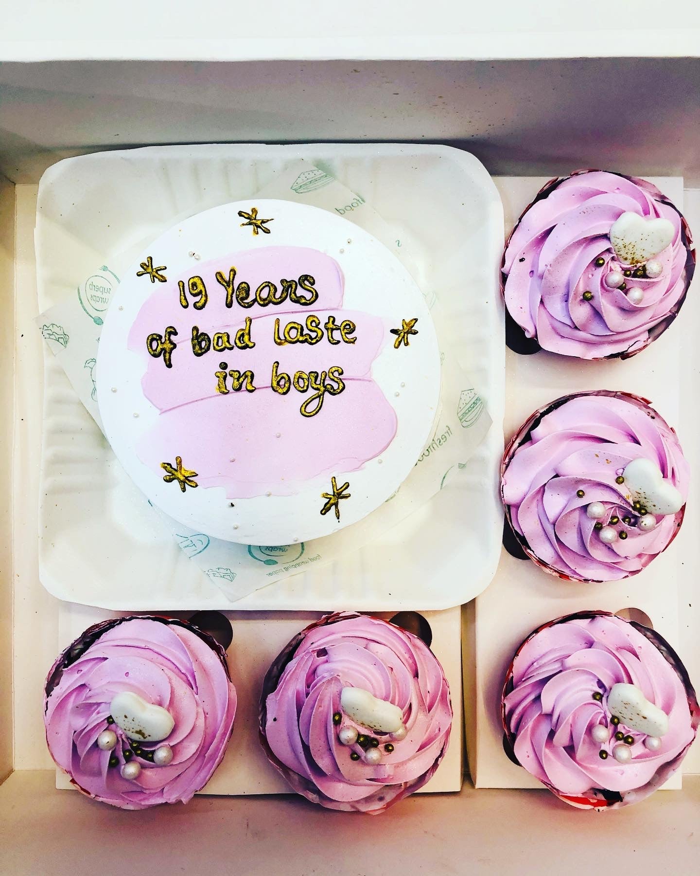 A combo cake is packed with 4 cupcakes and a mini cake with pink truffle. 