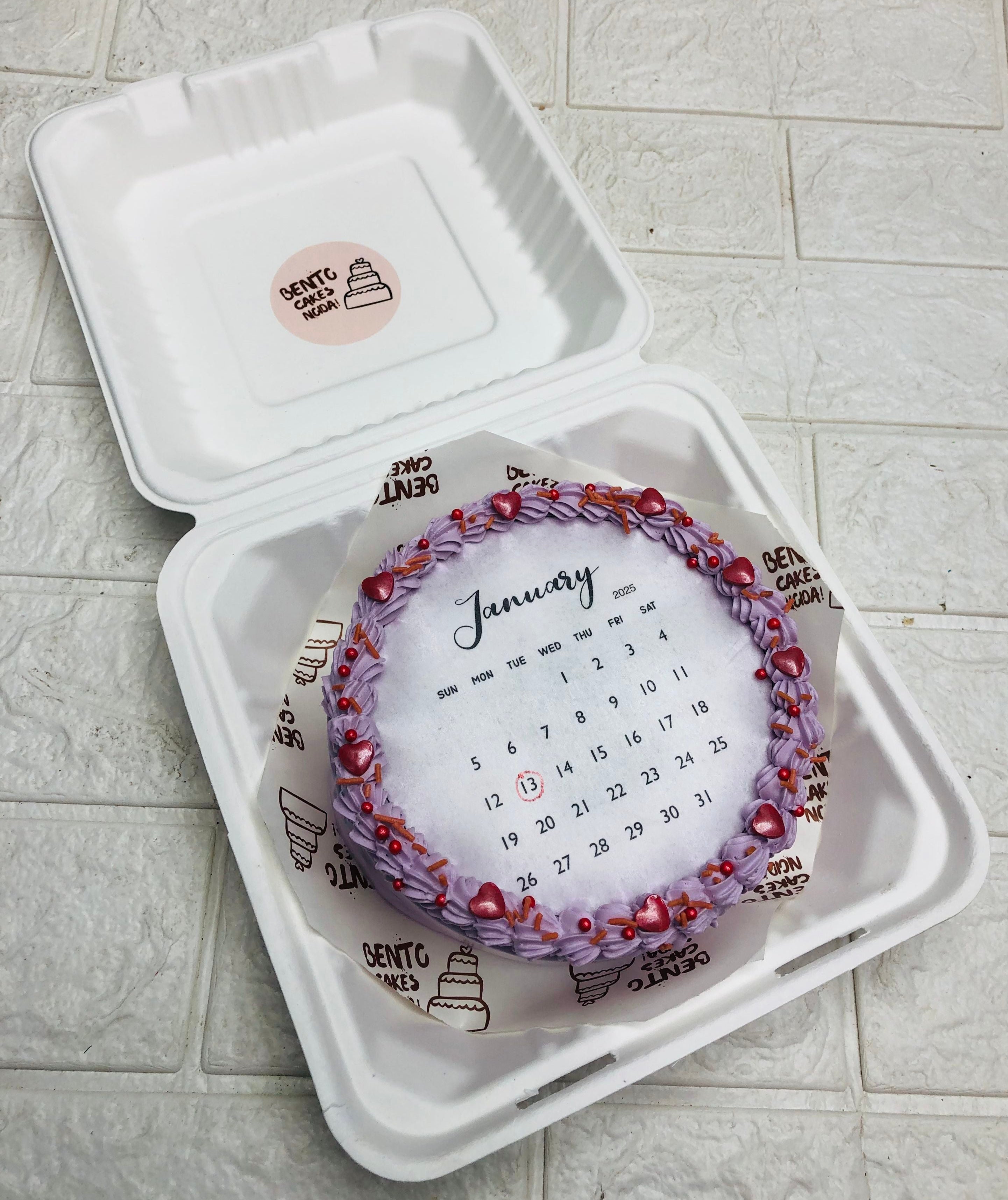 An aesthetic purple fire bento cake with january calendar design.