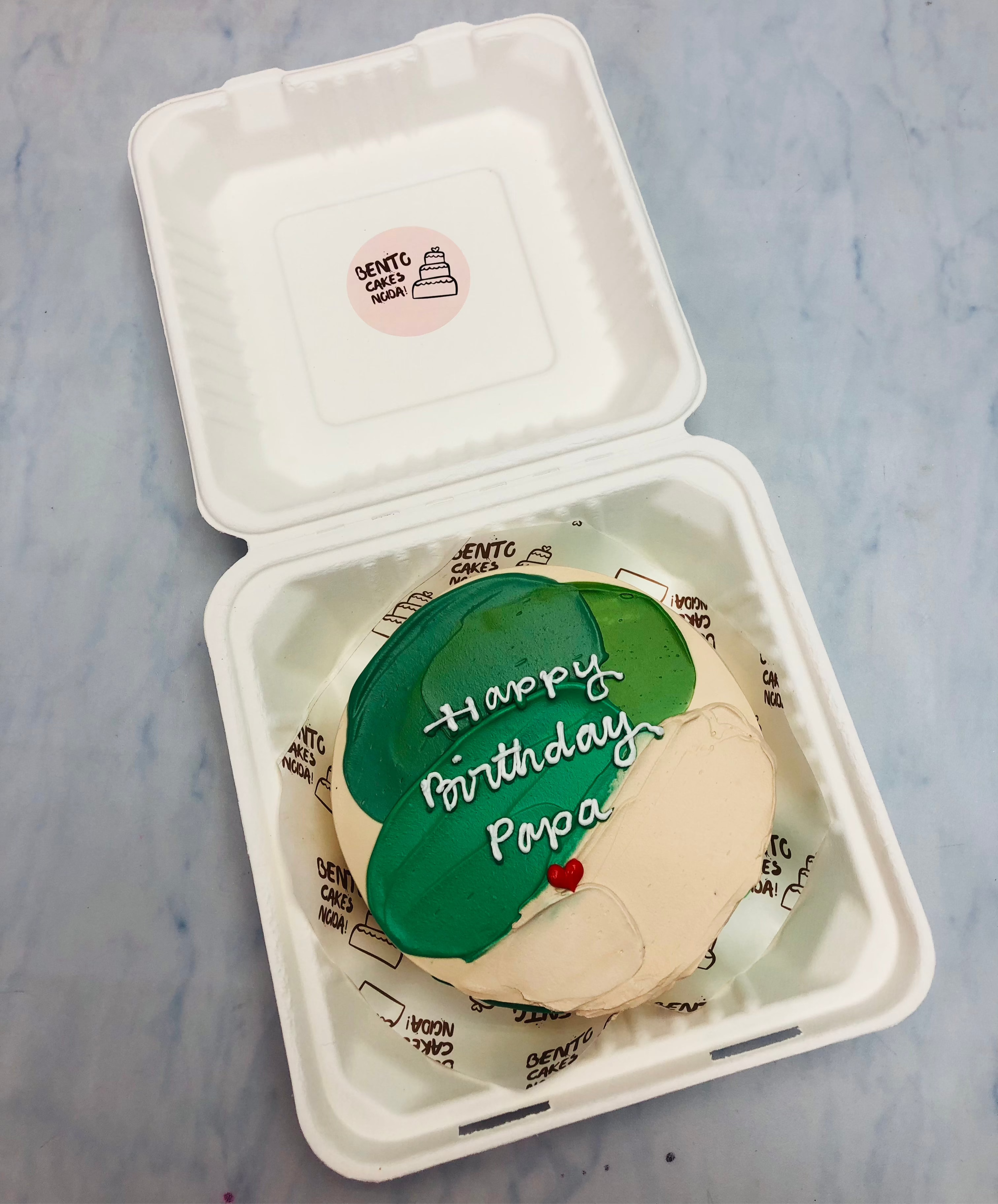A peach icing bento cake with green shades for papa birthday.
