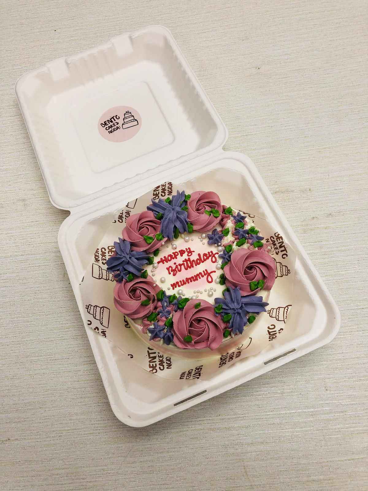 A colorful florals design on light pink cake for mom's birthday.