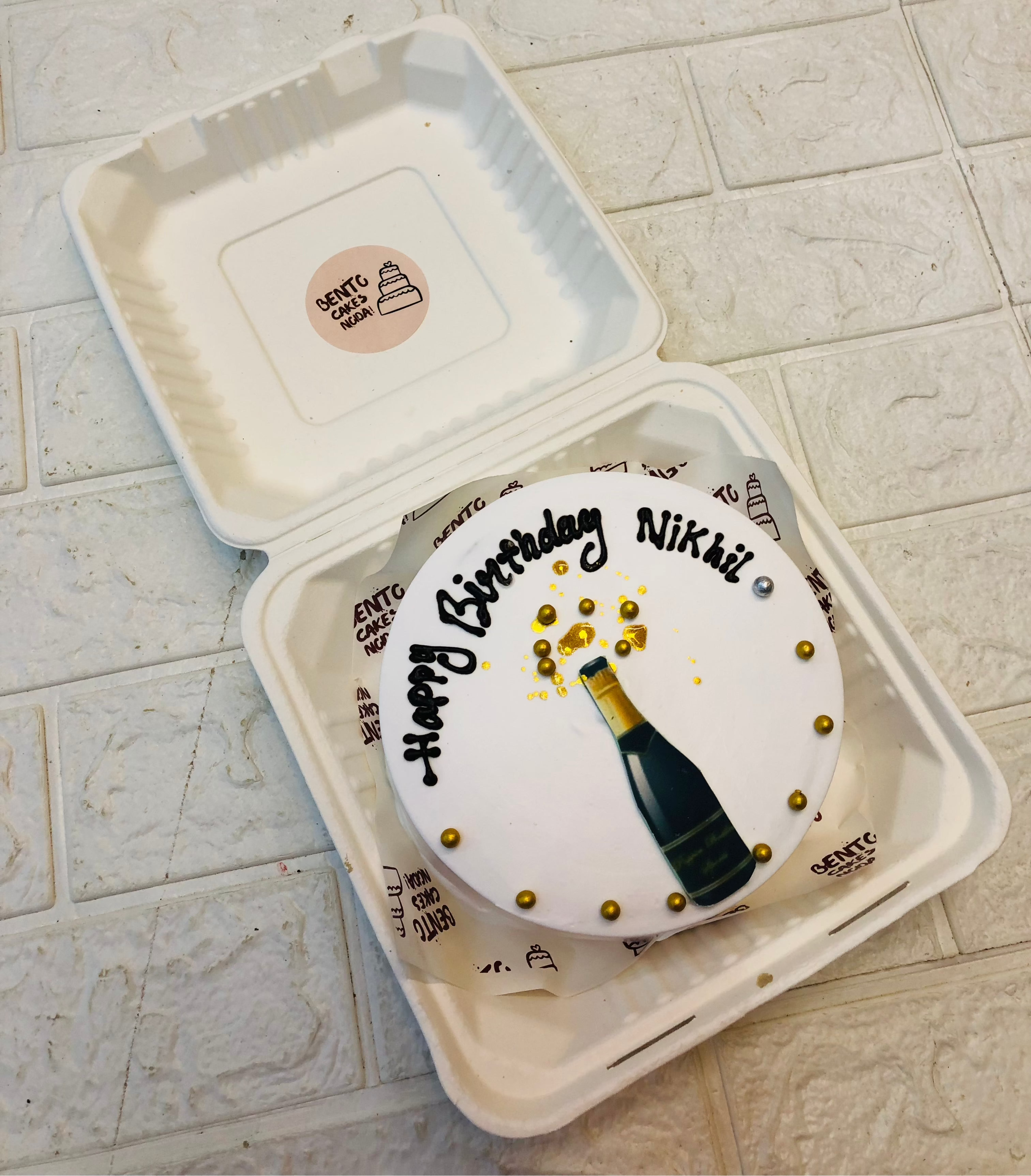 A shampion bottle print on a white bento cake for birthday celebration.