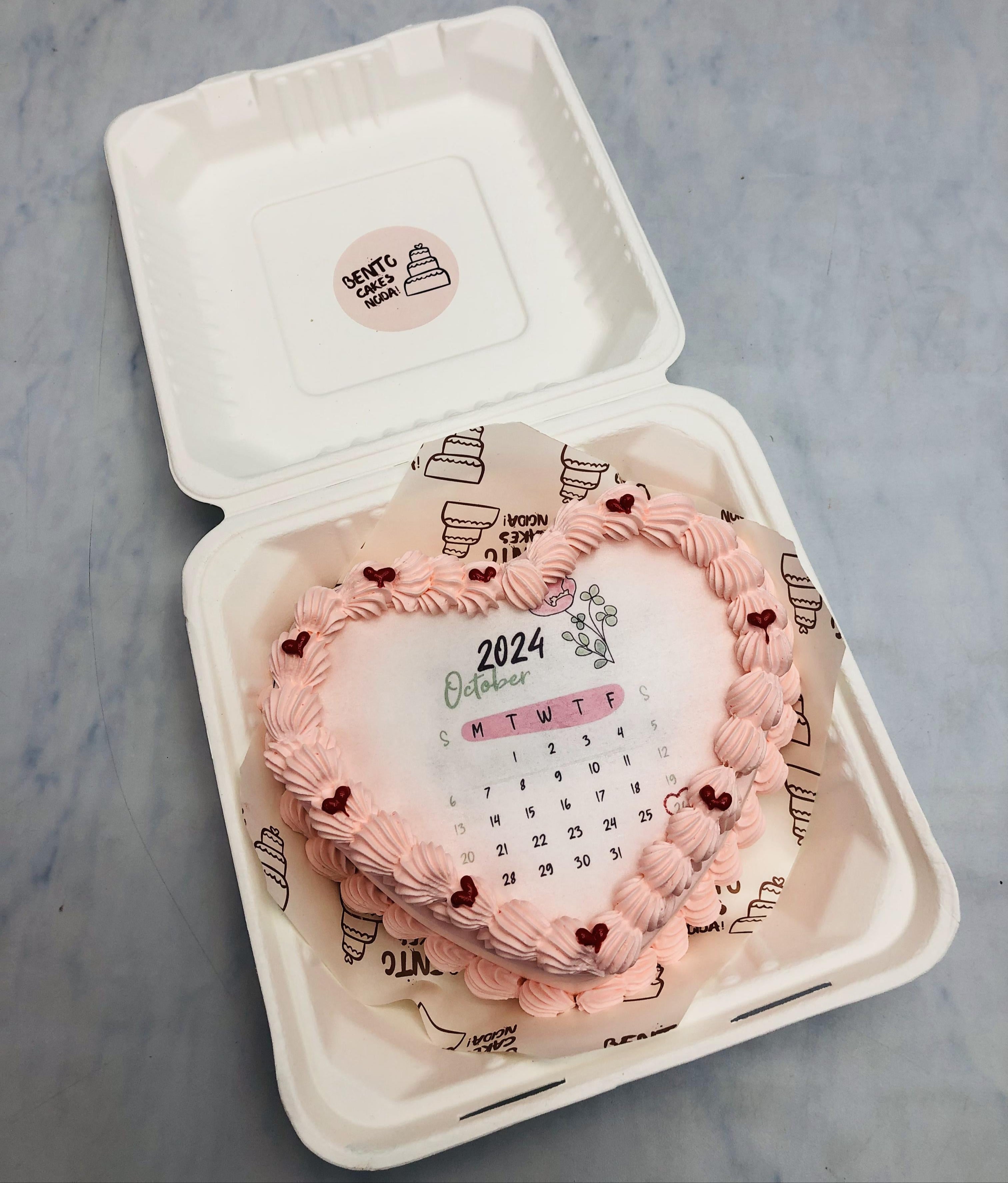 A baby pink designer heart shape fire bento cake with october calendar theme.