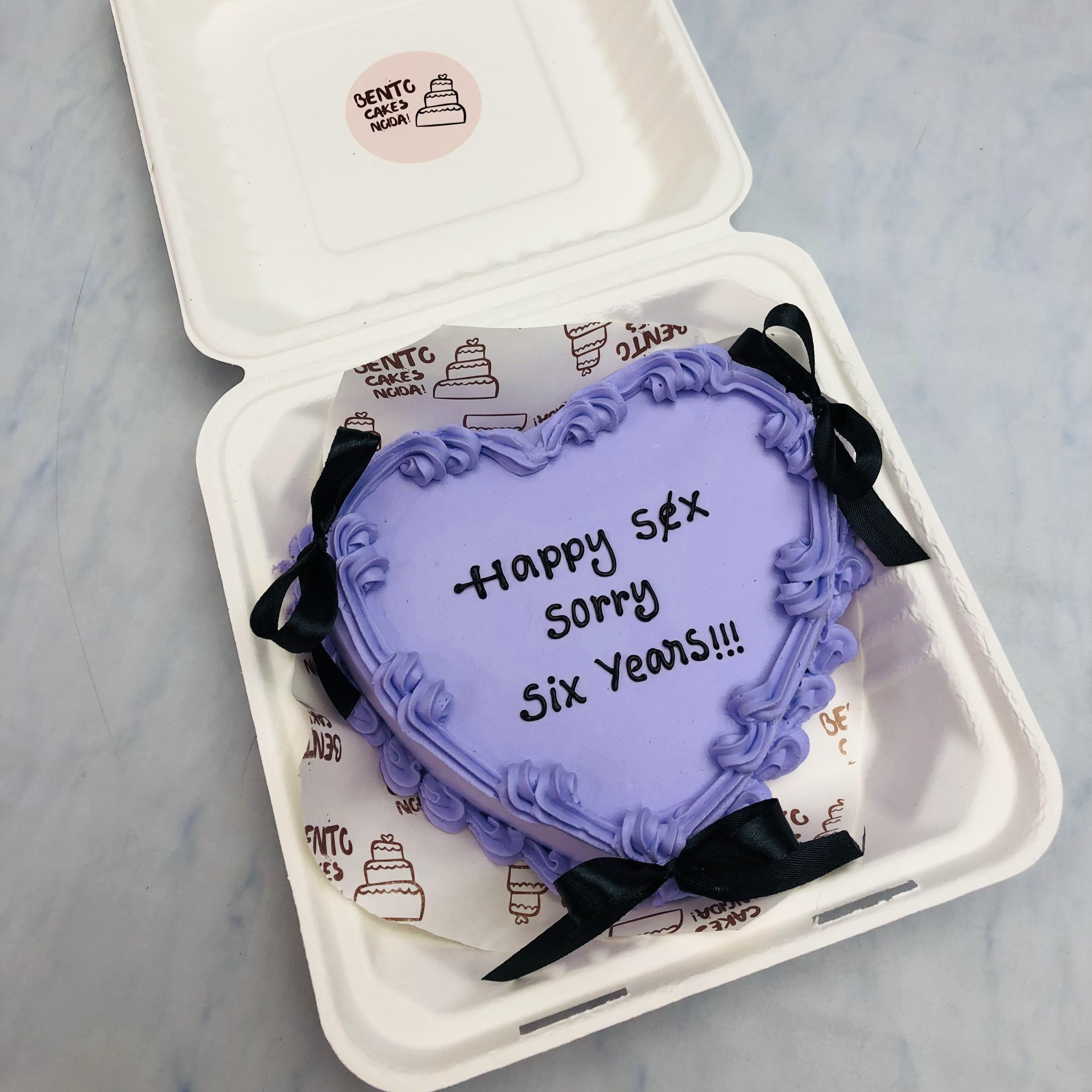 A Anniversary Theme Blue heart shape bento cake with black biows on it.
