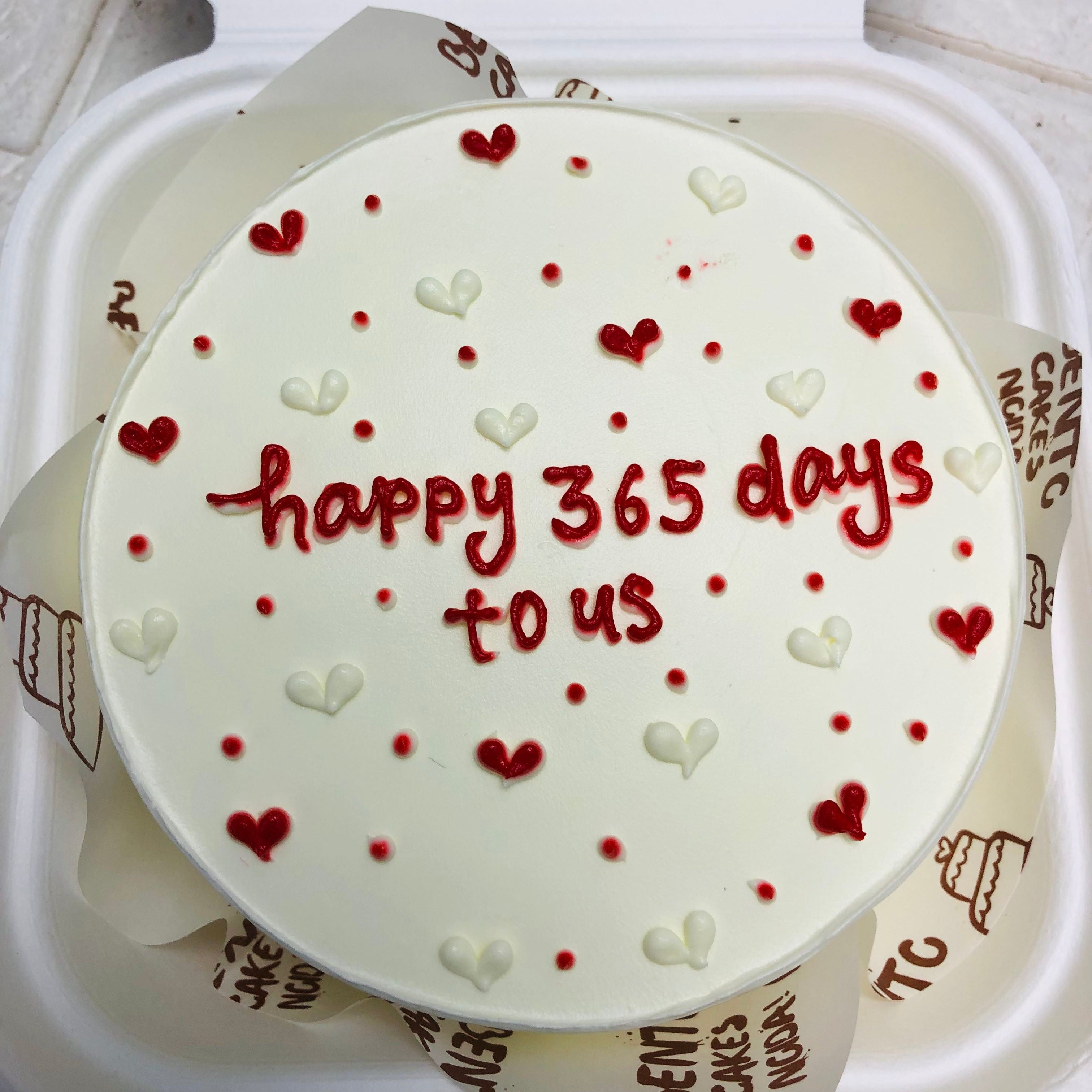 A pretty white mini bento cake is designed with red and white hearts for 1st anniversary. 
