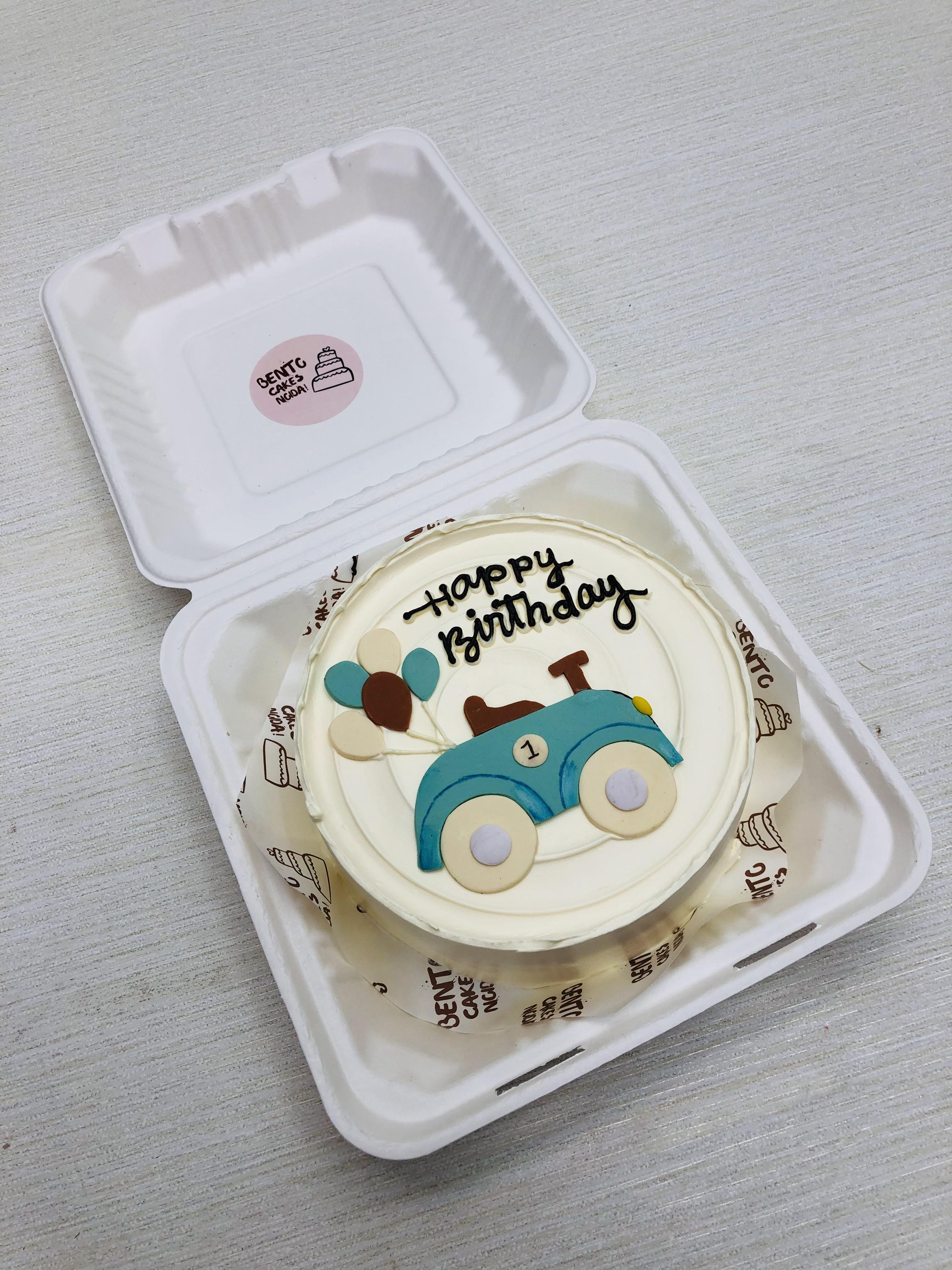 A white bento cake having toy cakr cake design.