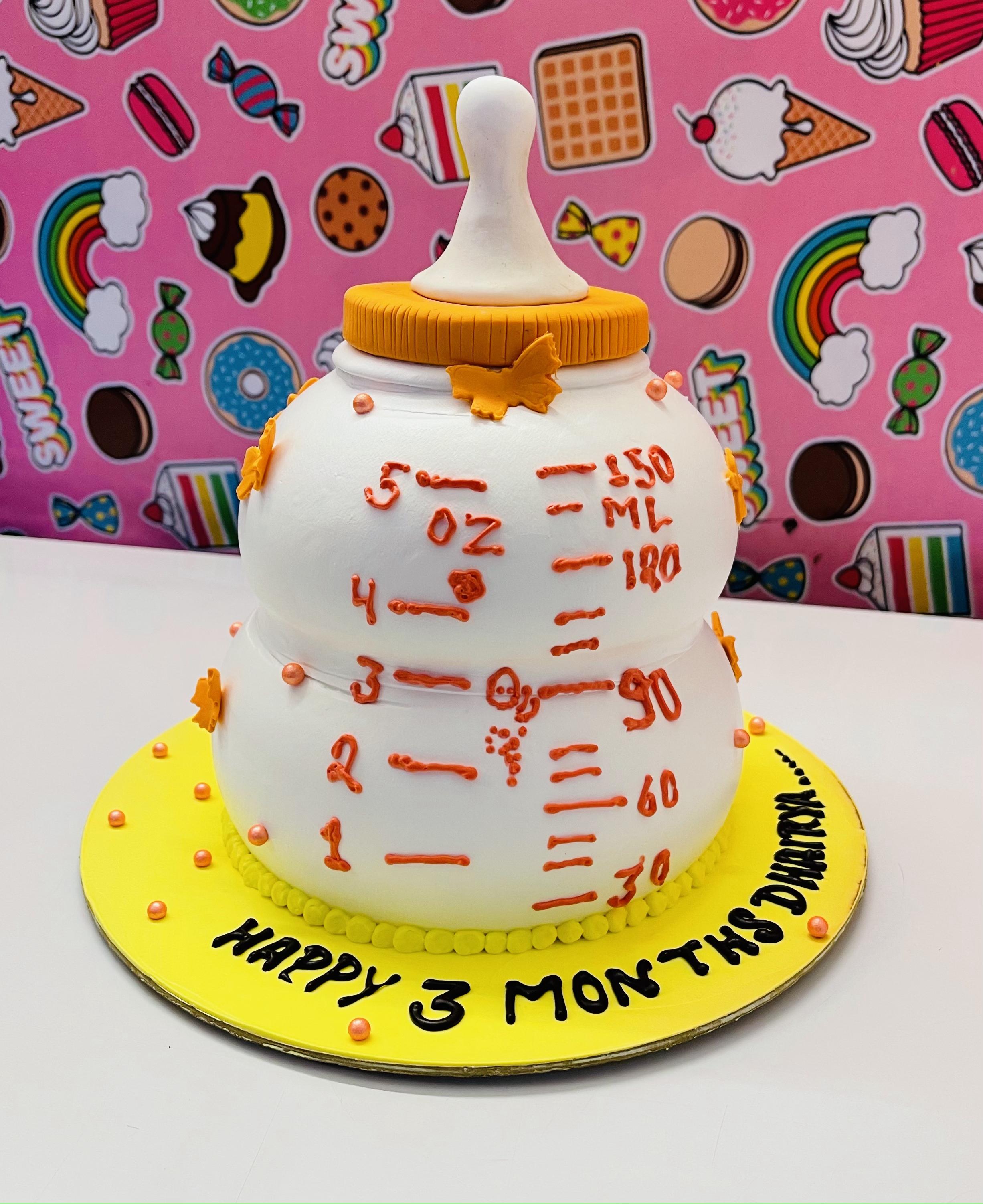 A white designer cake in shape of baby feeding bottle.