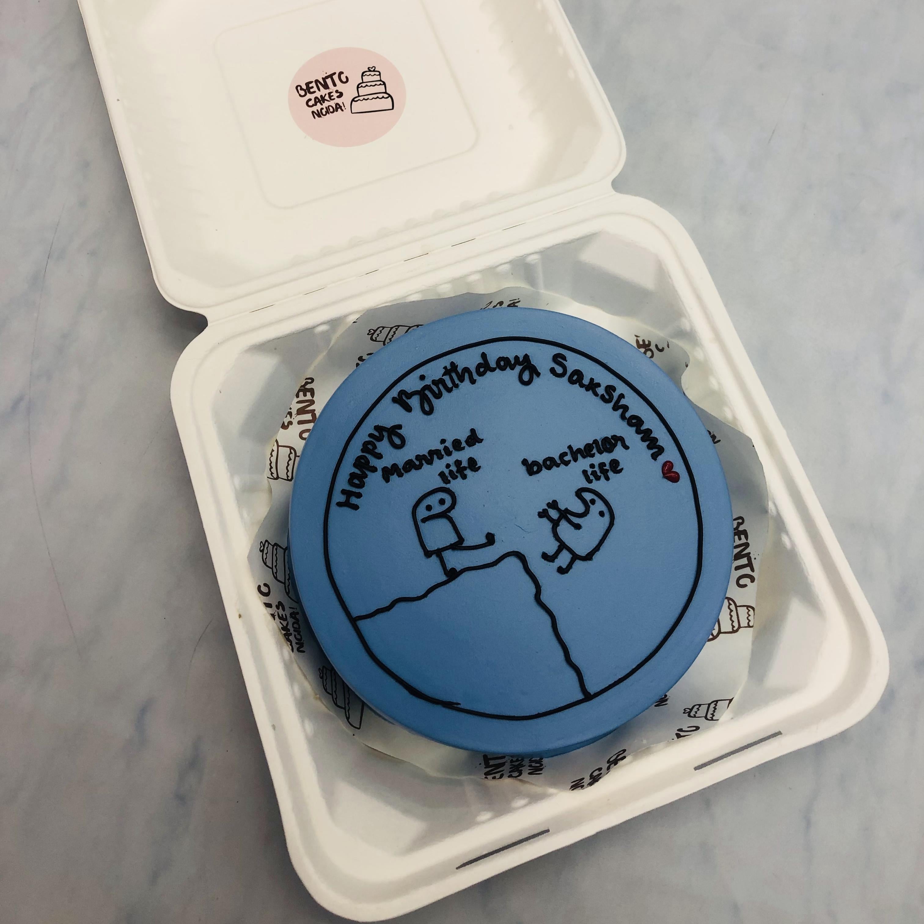 A dark blue bento cake with mimi's life change theme from bachelor to married.