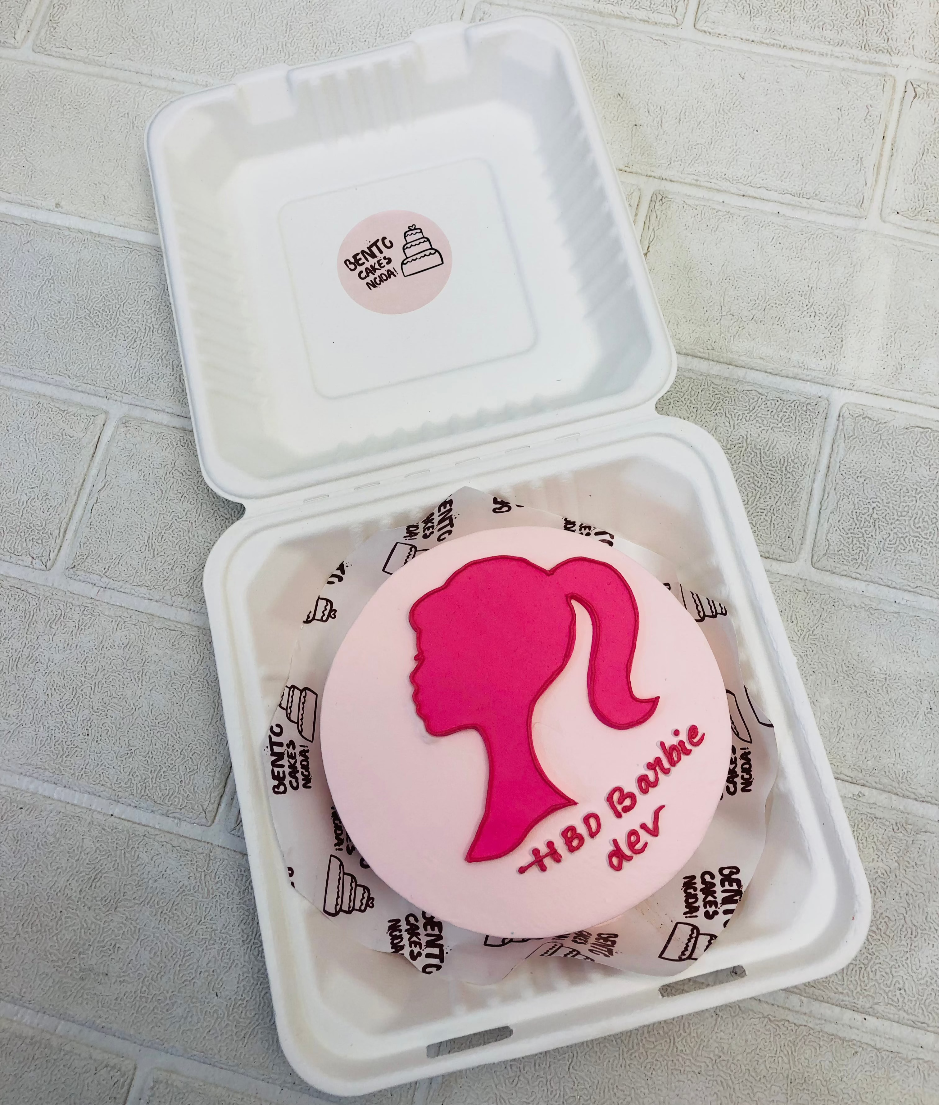 A light pink bento cake having a barbie girl design with pink fondant for her birthday.