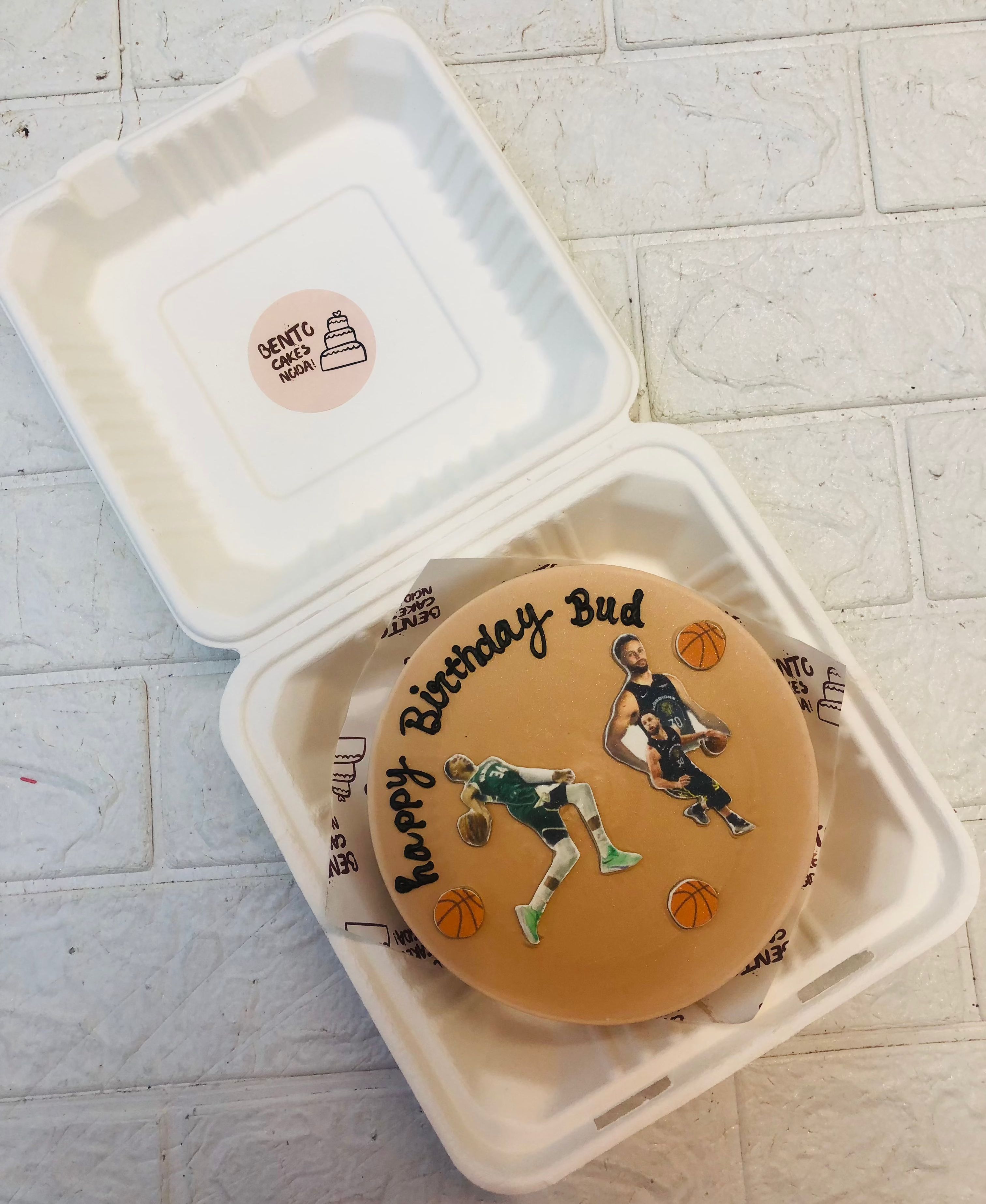 A brown bento cake is designed with basket ball sports lovers, playing basketball.