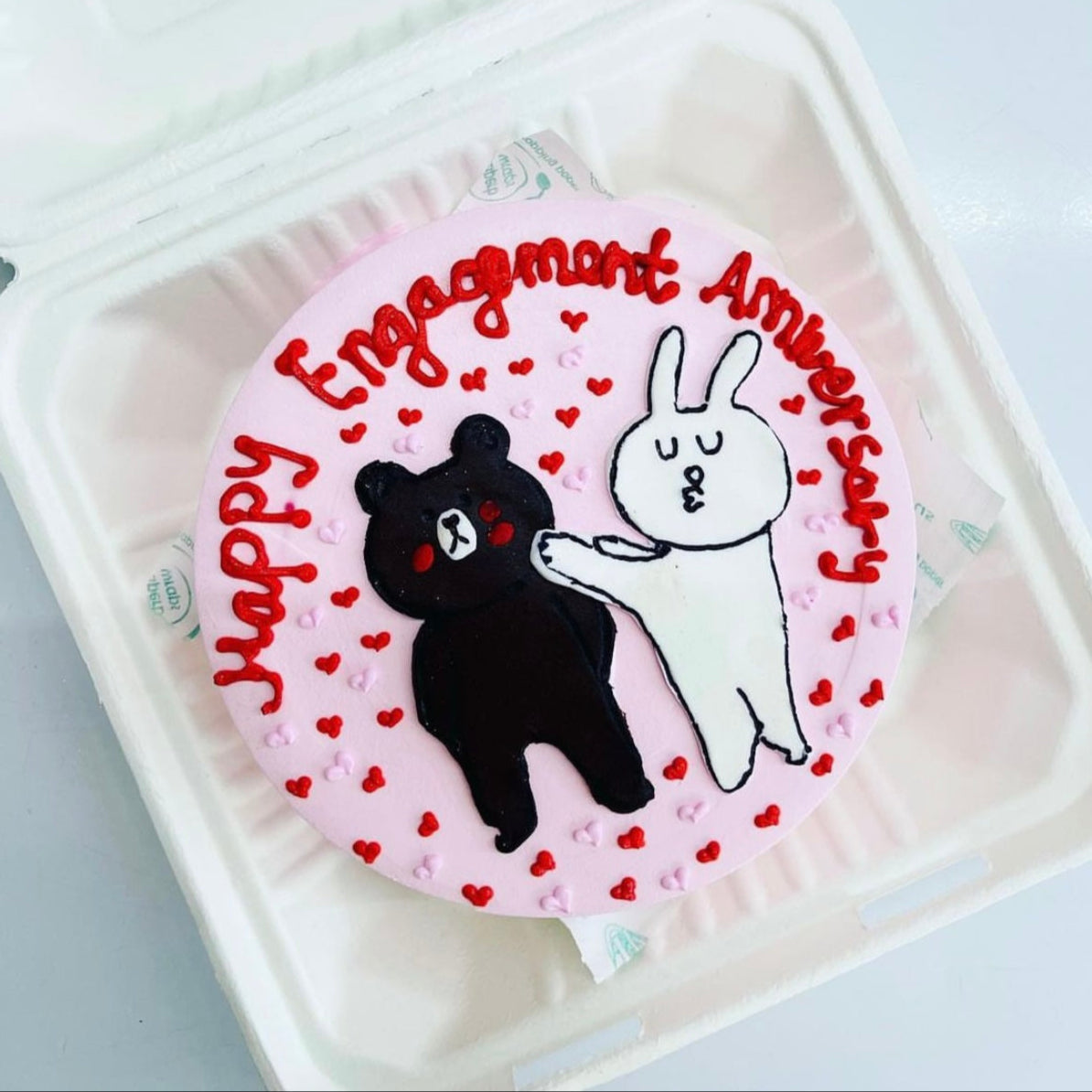 A charming cake adorned with a bear and Rabbit, and a heart, ideal for special occasions.