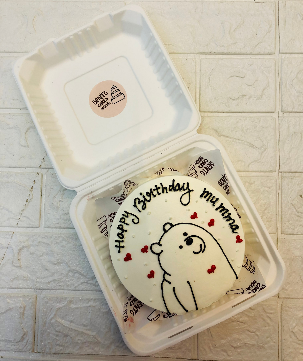 A cute bear drawing with black icing for Mumma's Birthday and decoated with red hearts design.
