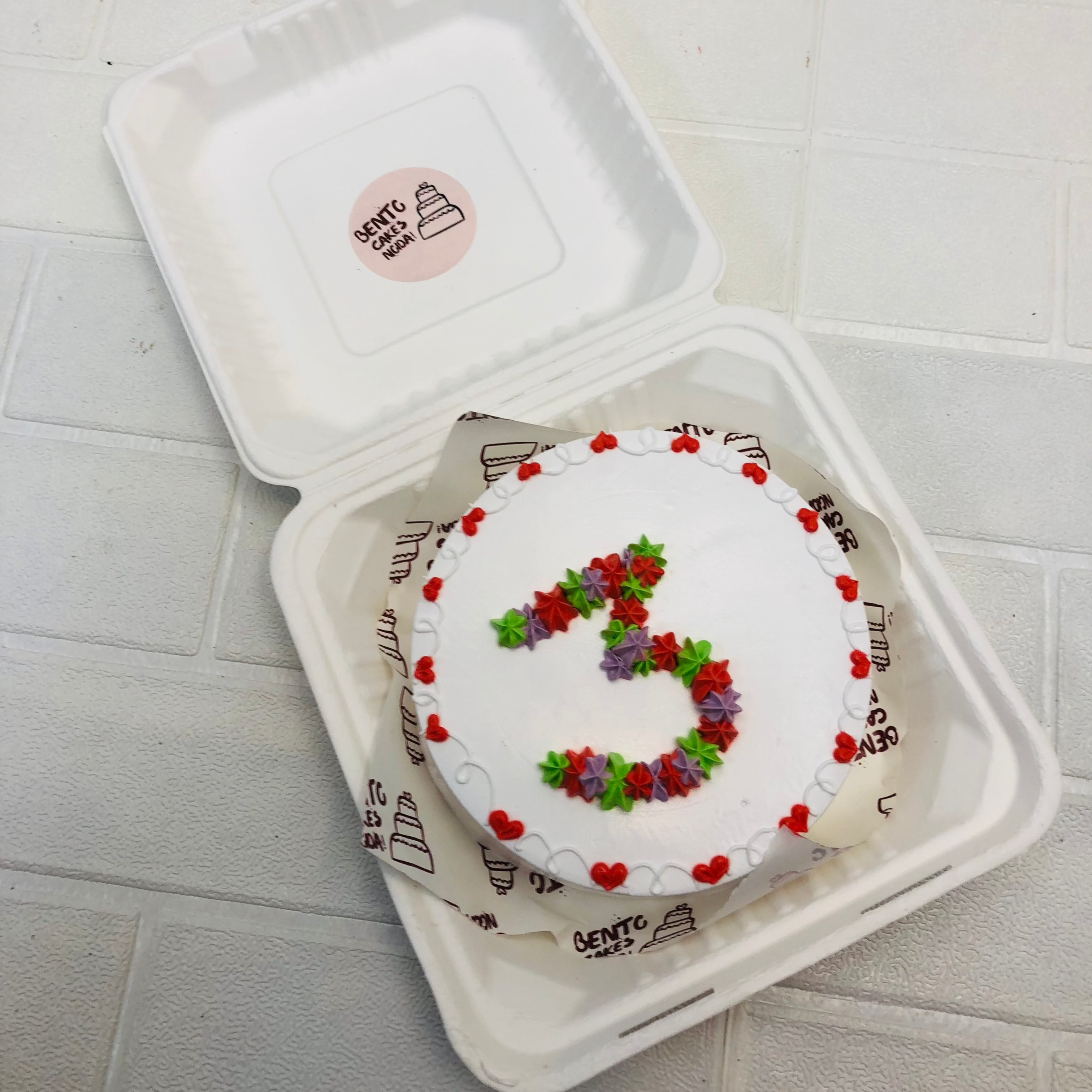 A white bento cake with colorful 3 number design.