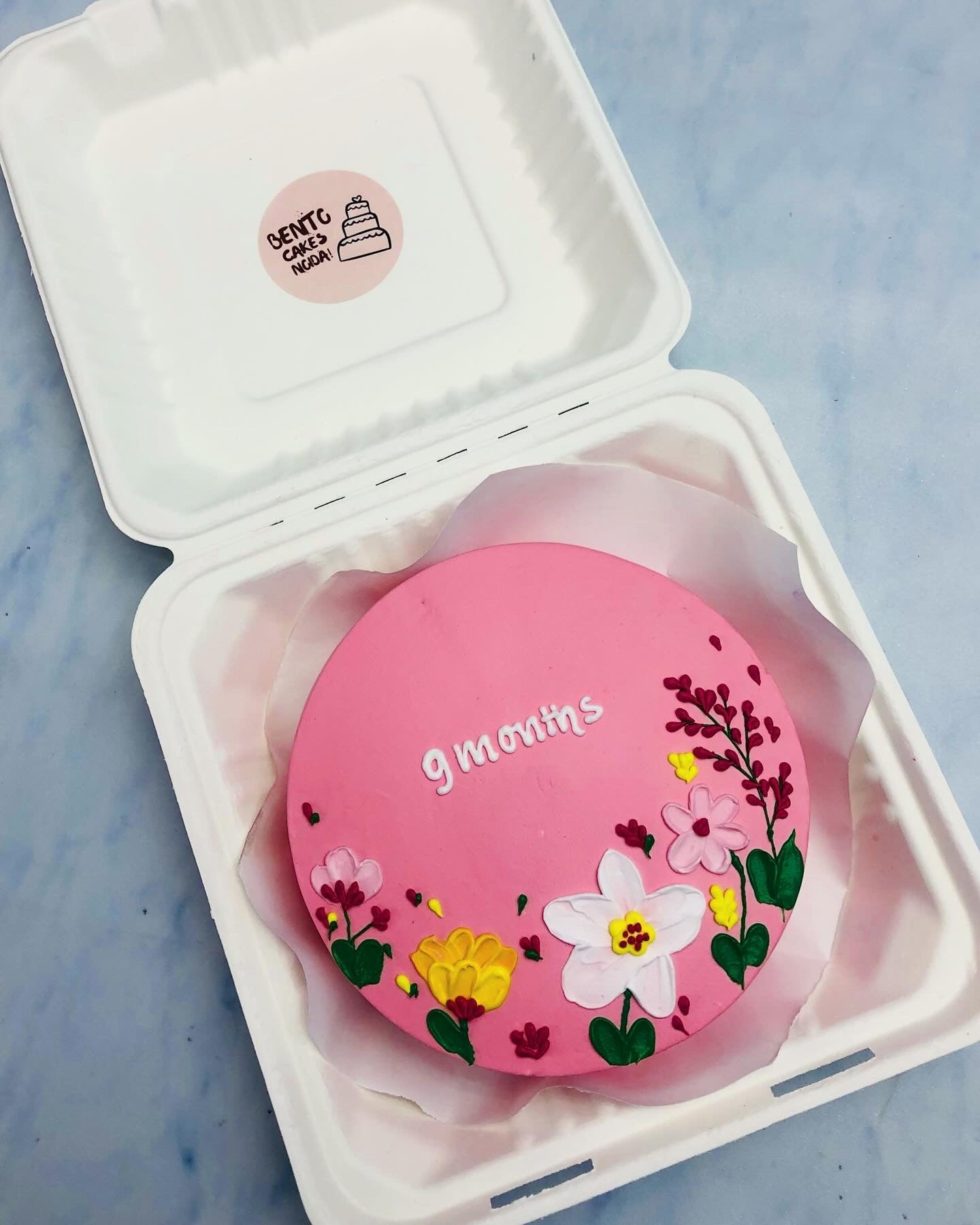 A light pink bento cake with beautiful floral designs and for 9 months baby.