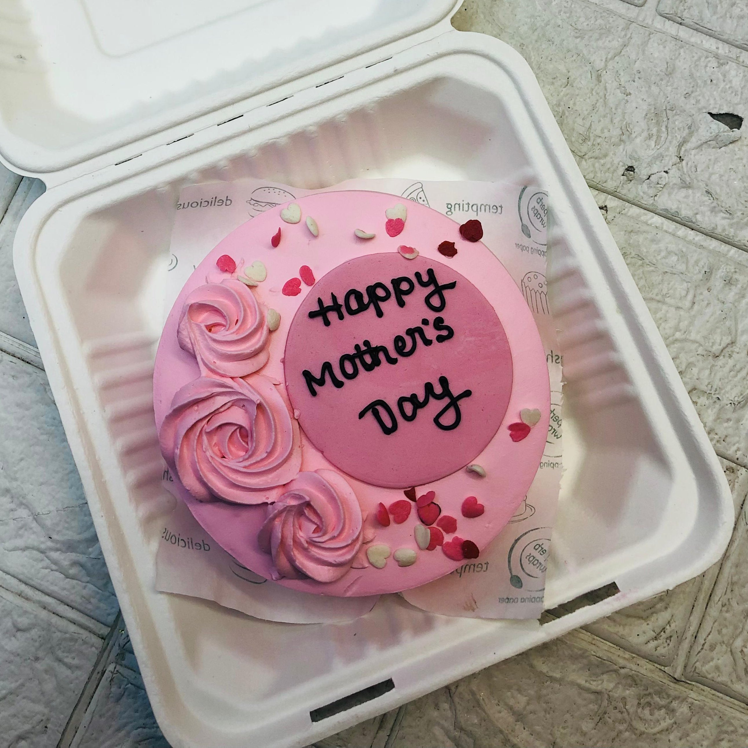 A light pink color cake with light pink floral design and pink fondant work on it and is designed for mother's day.