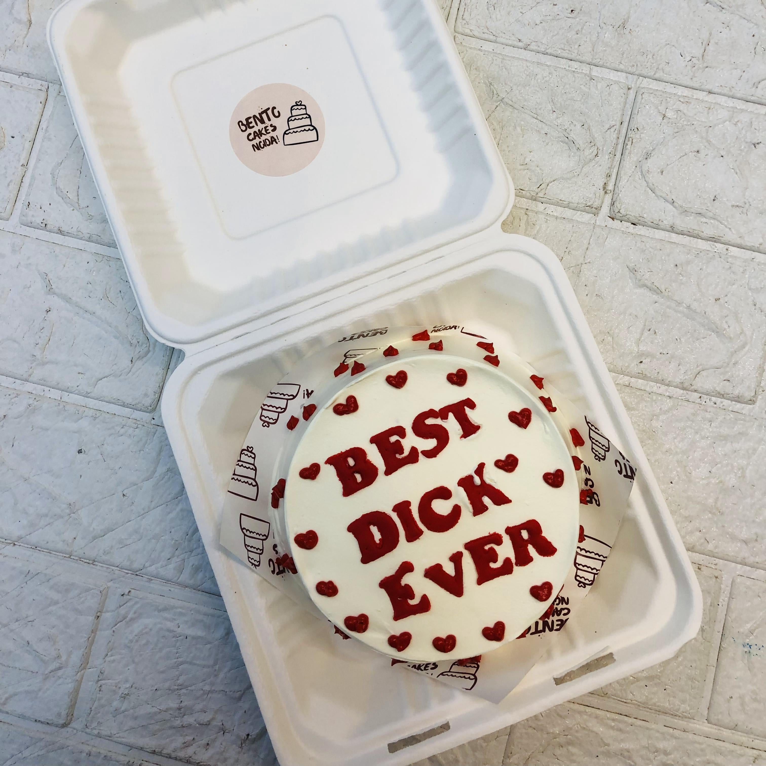 A decorative hearts design on white bento cake and a text written with red fondant letters.