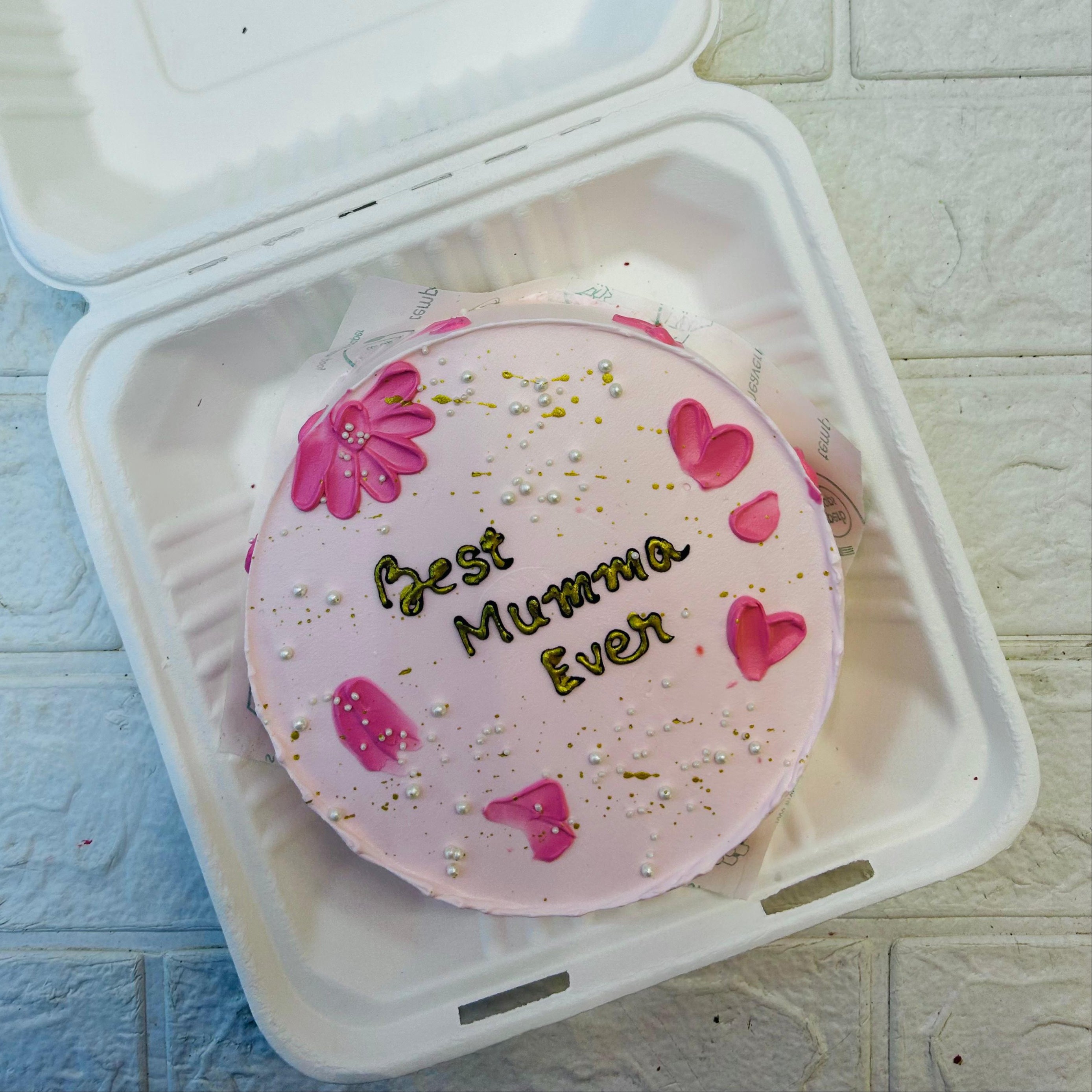 A light pink ake with pink shades on it and a "Best Mumma Ever" Text written on  it.