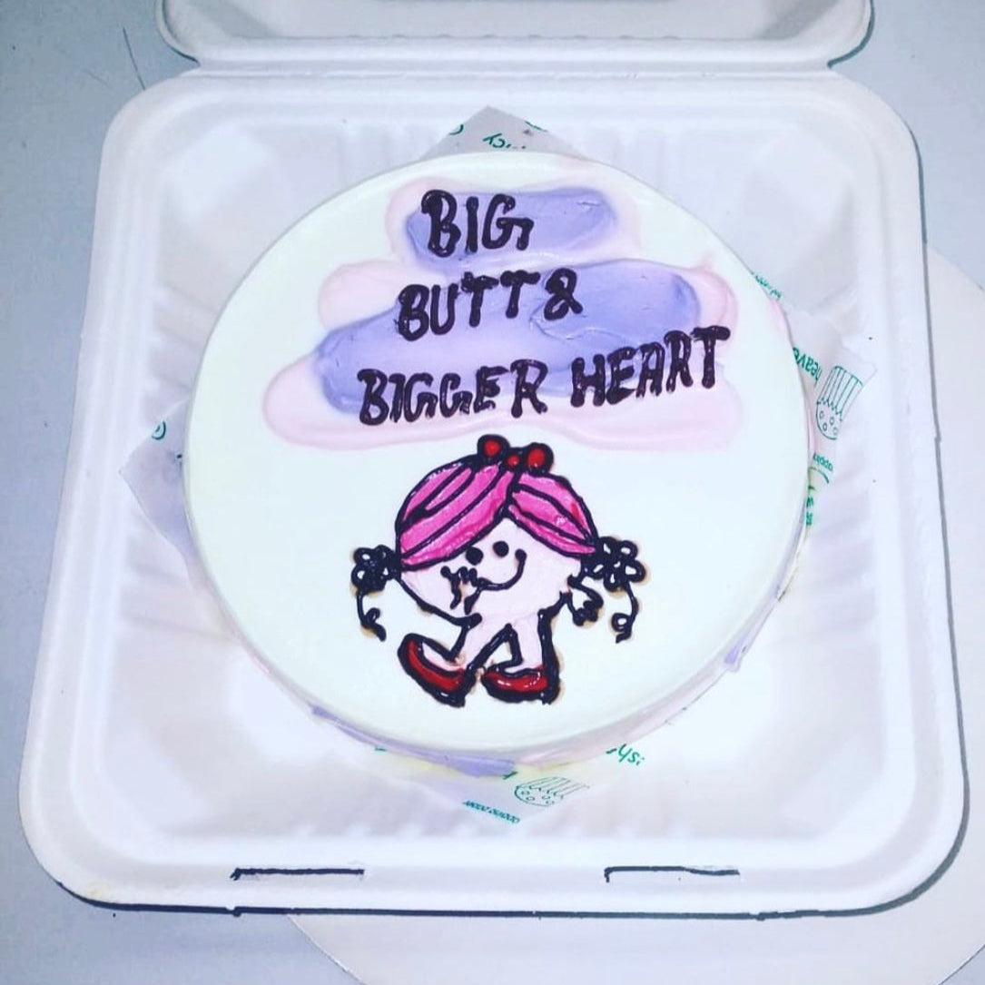 A beautifully decorated cake featuring a drawing of a girl on its surface, showcasing artistic design and creativity.