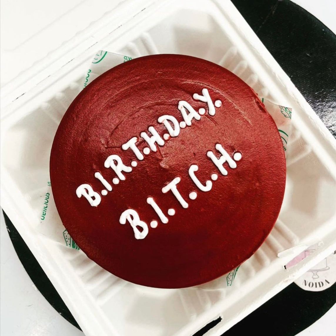 A birthday cake featuring the word "bitch" elegantly decorated on top, showcasing a playful and bold design.