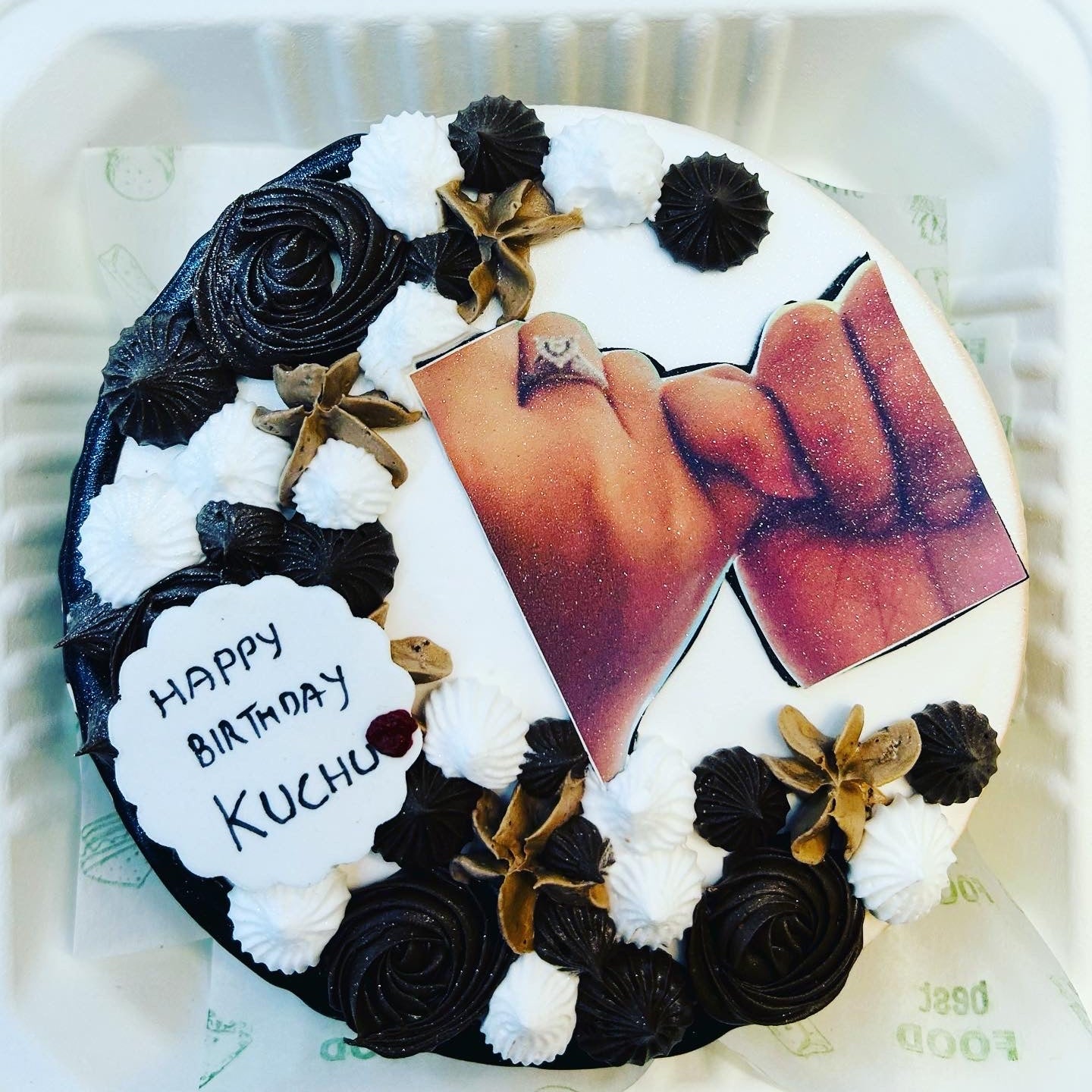 A beautifully decorated cake featuring an image of a couple sharing a kiss, symbolizing love and celebration.