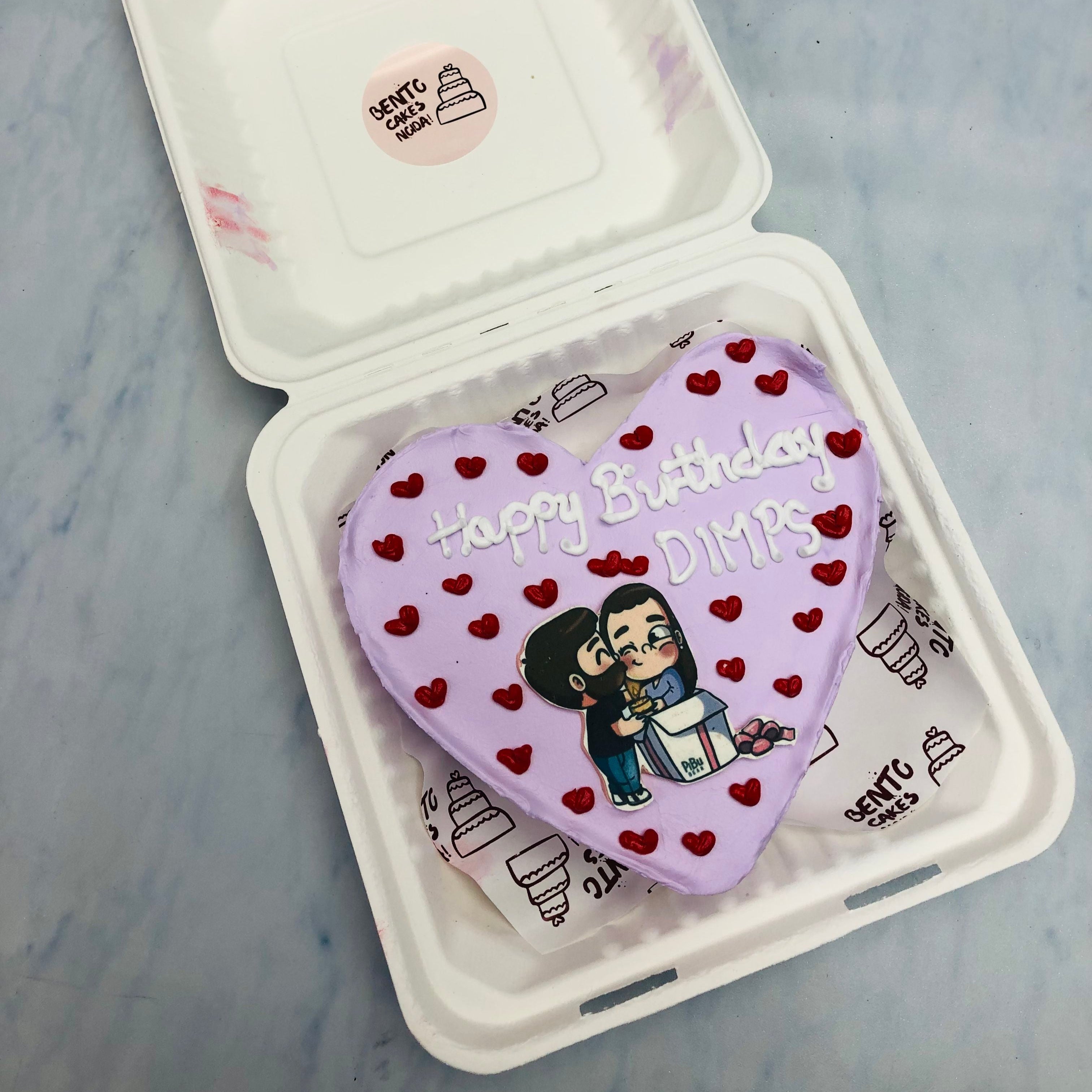 A light purple heart shape cake full of red mini hrts design on it with a kissig couple sticker on it.