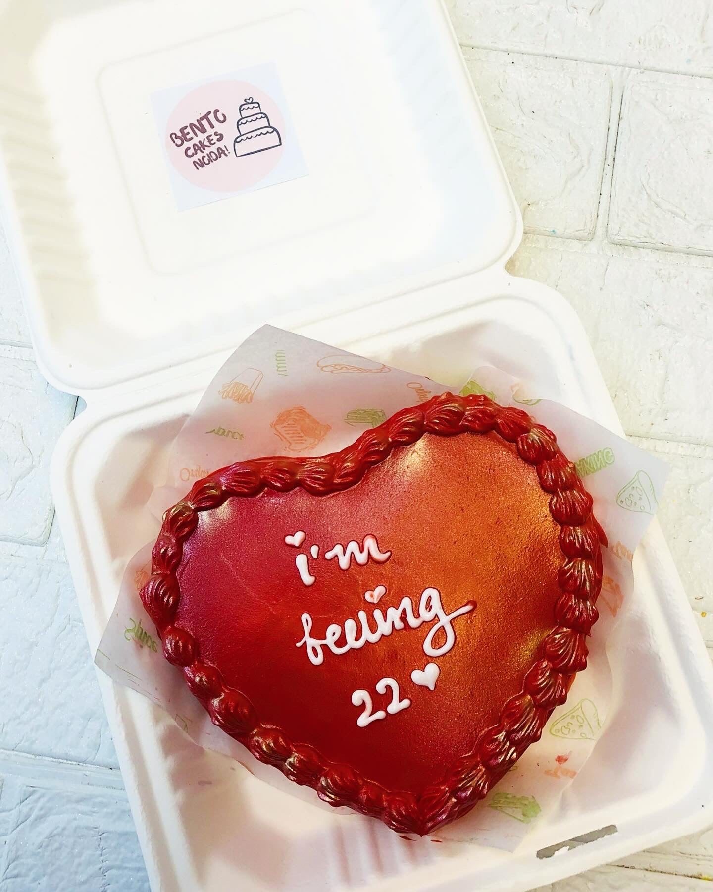 A birthday theme dark red color heart shape bento cake with white text on it.