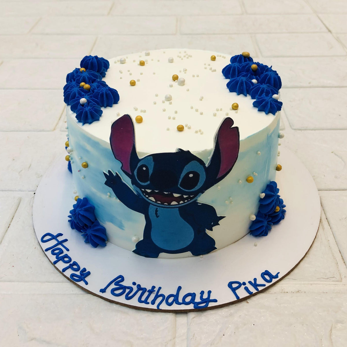 A white blue combination cake is decorated with blue cream on top and its sides and having a dinosaurs print on its side.