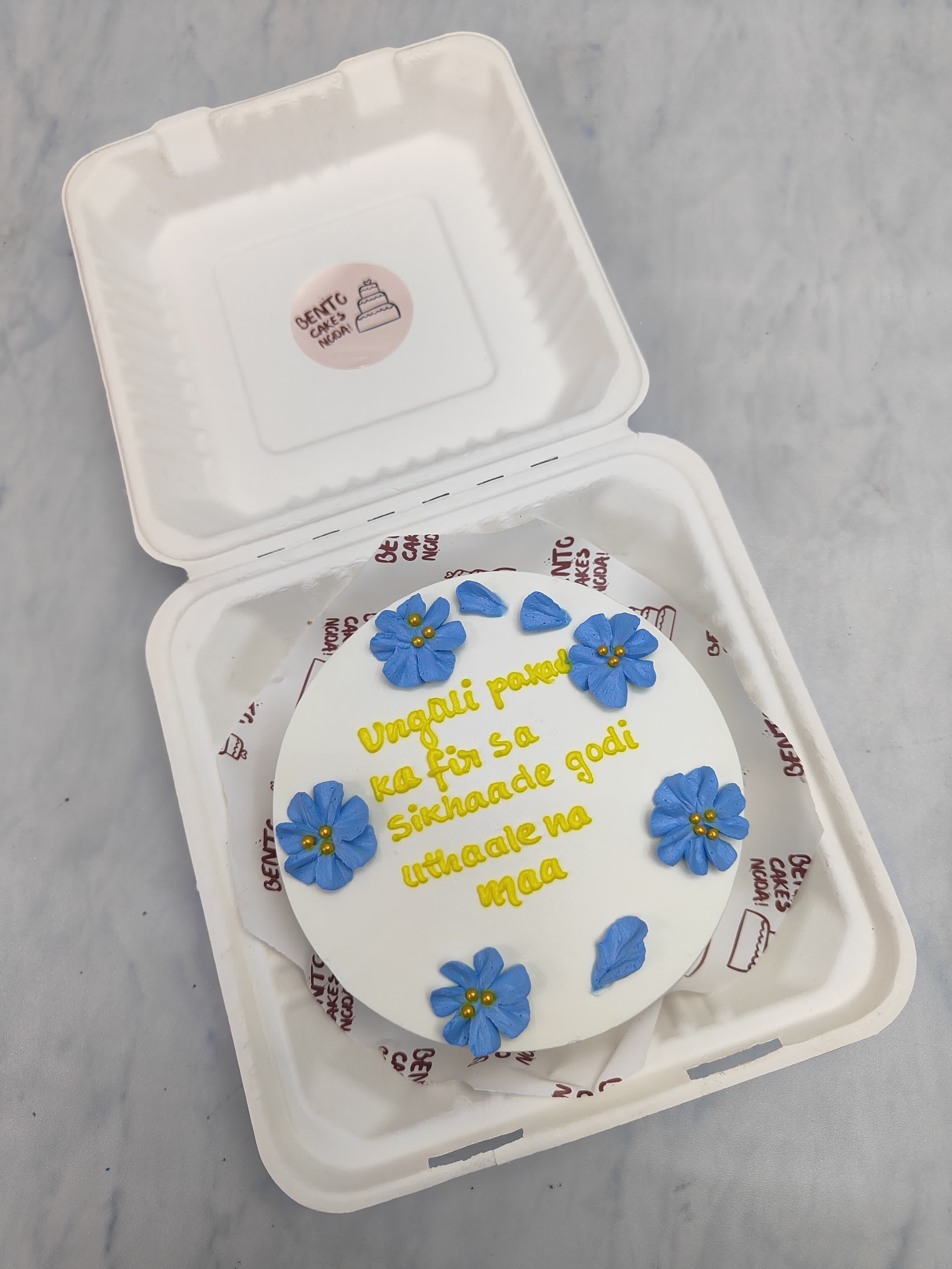 A blue floral bento cake designed for mothers day special with a loving message written on it.