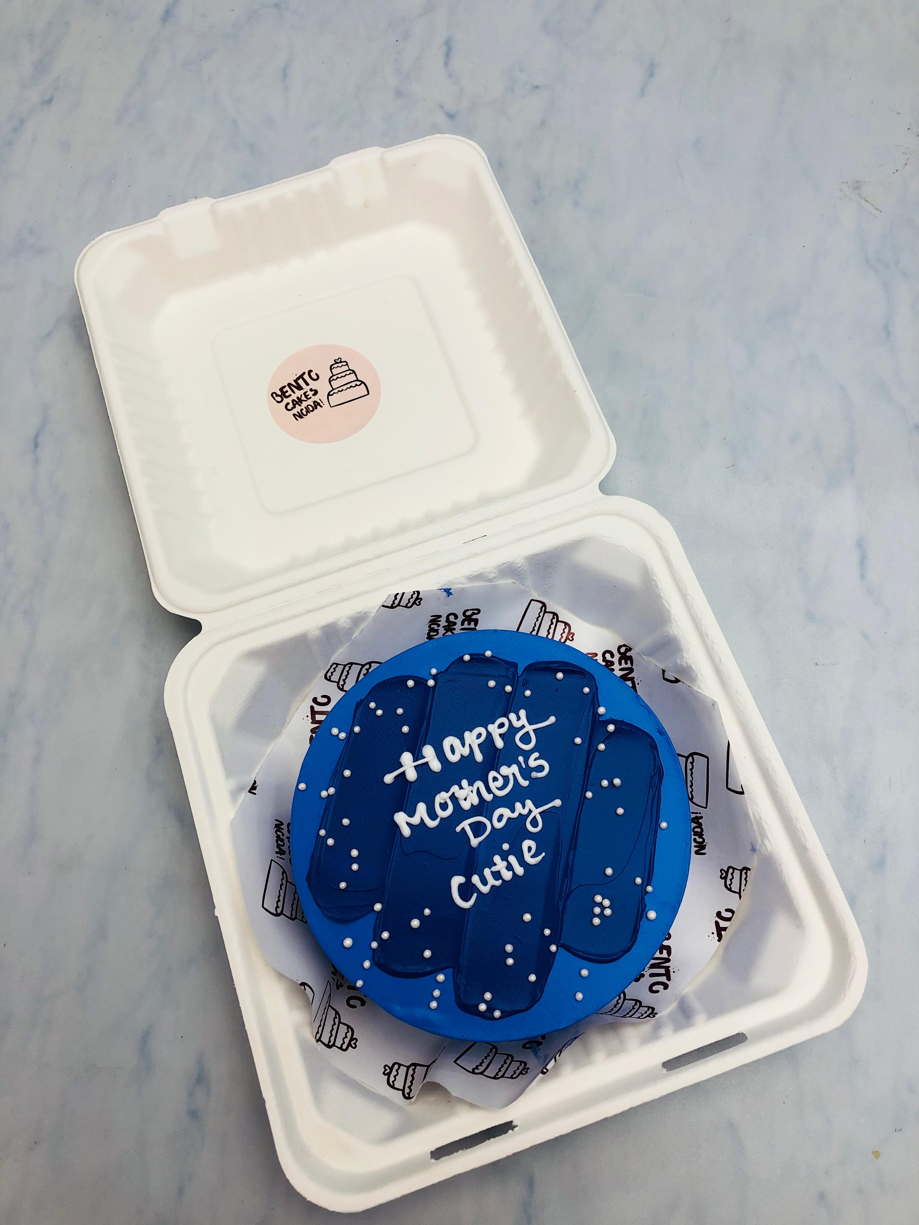A blue color cake with dark blue shades and white sprinkles on it.