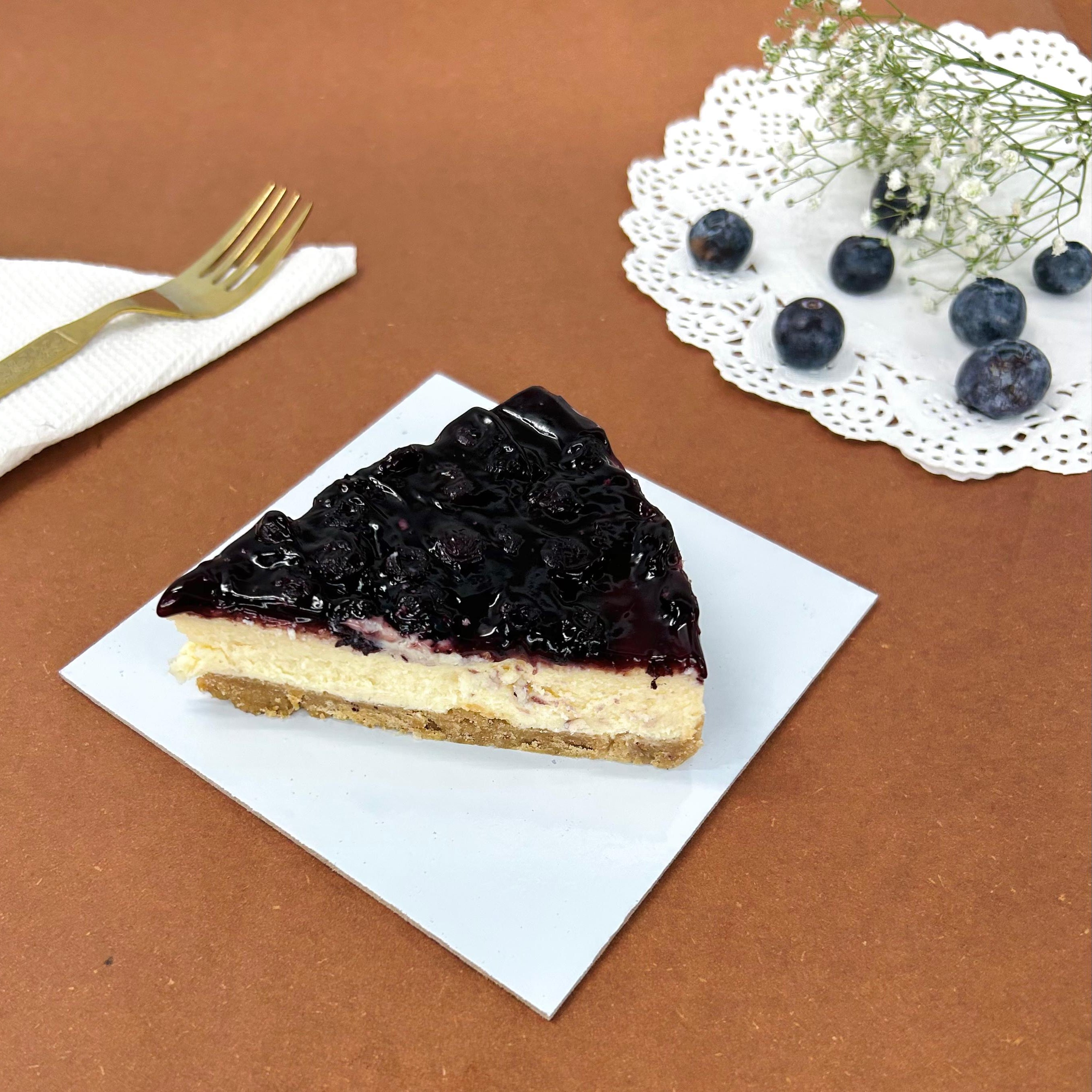 A Blueberry Cheesecake slice rich in fresh blueberry.