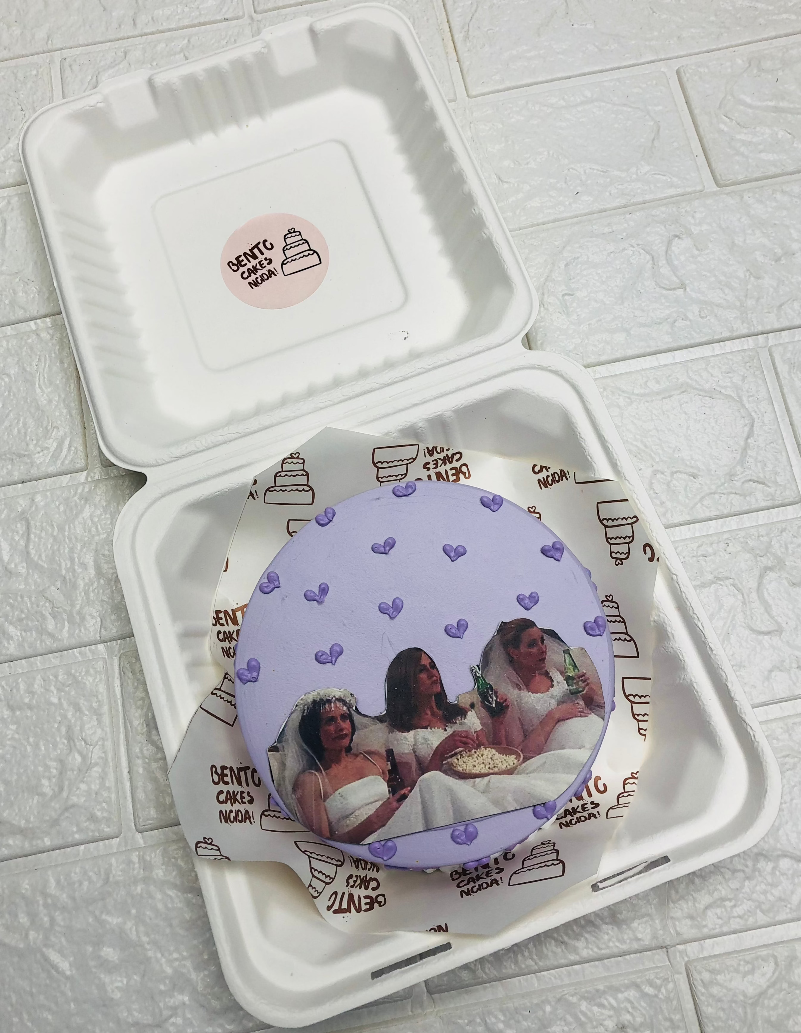 A bride to be theme purple bento cake with bridal photo prints on it.