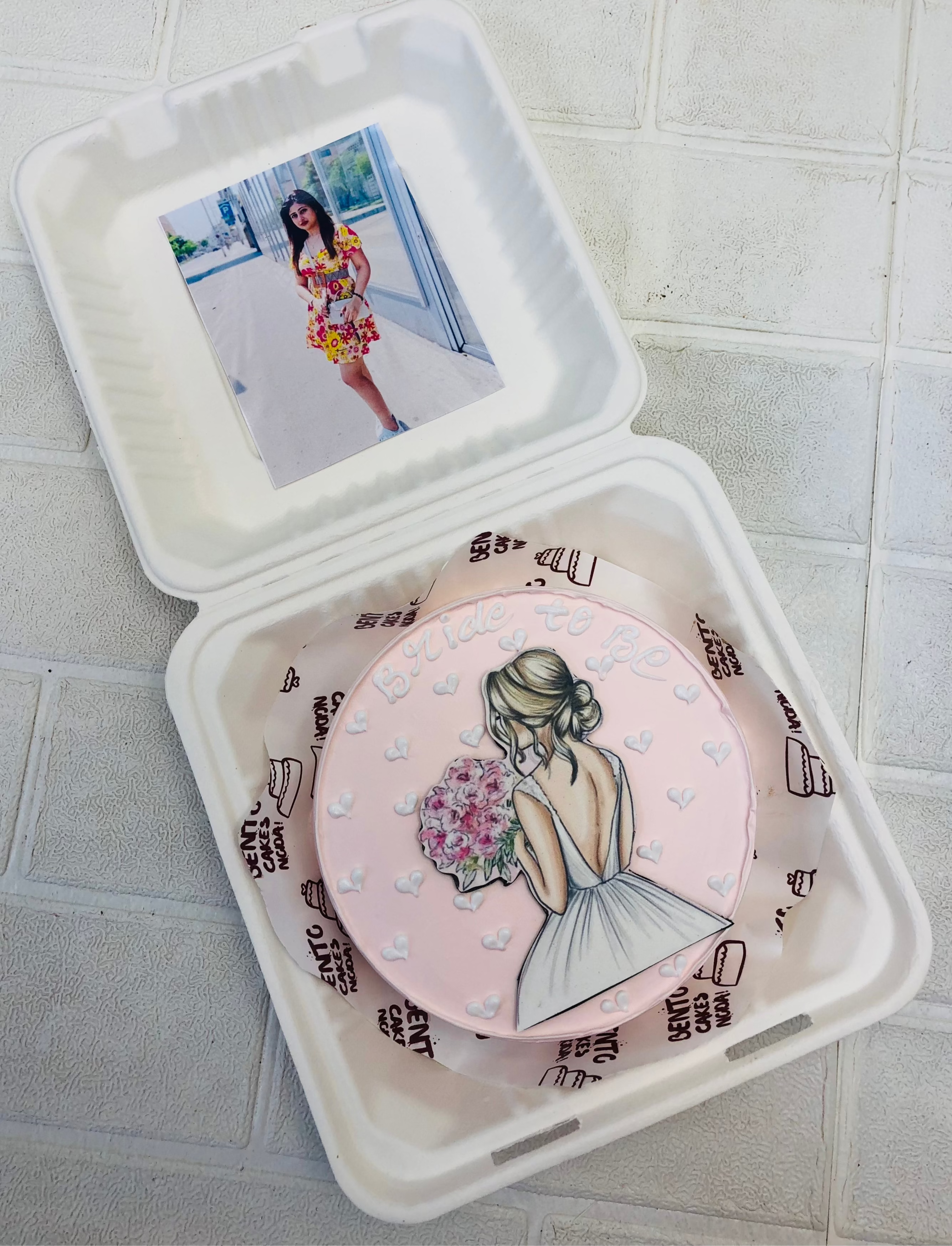 A peach color bento cake with a bride to be girl print on cake and girls photo on the box.