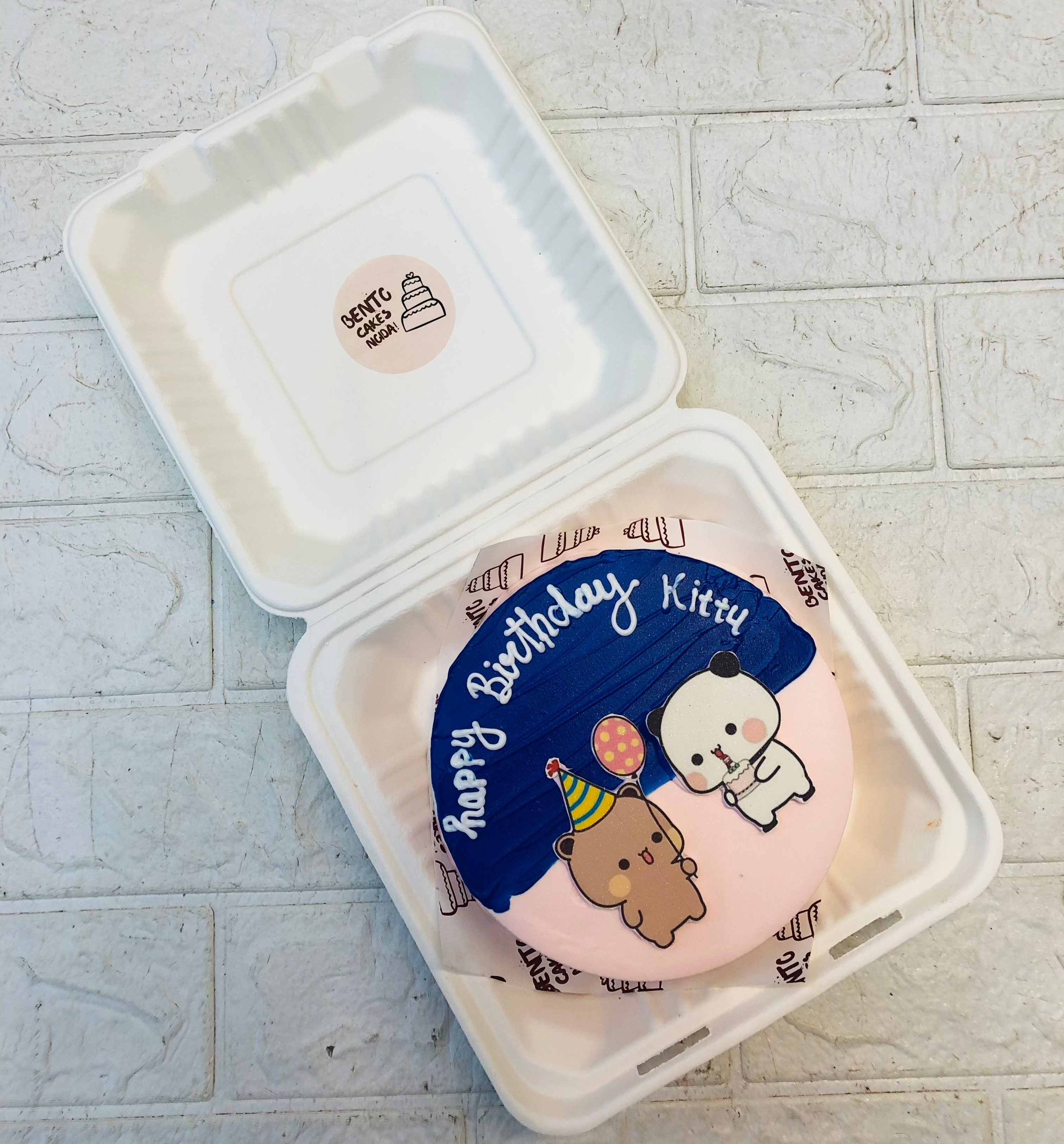 A peach- blue bento cake having bubu dudu cartoon character celebrating birthday.