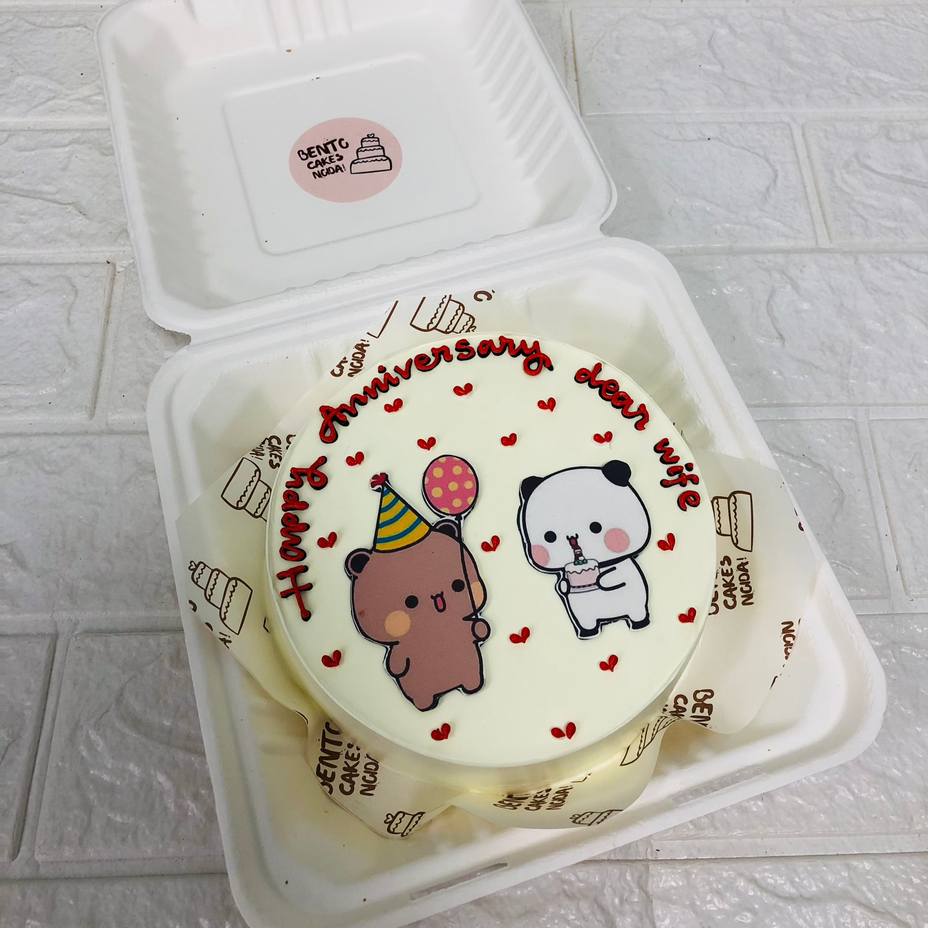 A delightful anniversary cake featuring a cute bubu dudu with balloon on top, decorated with colorful frosting and hearts design.