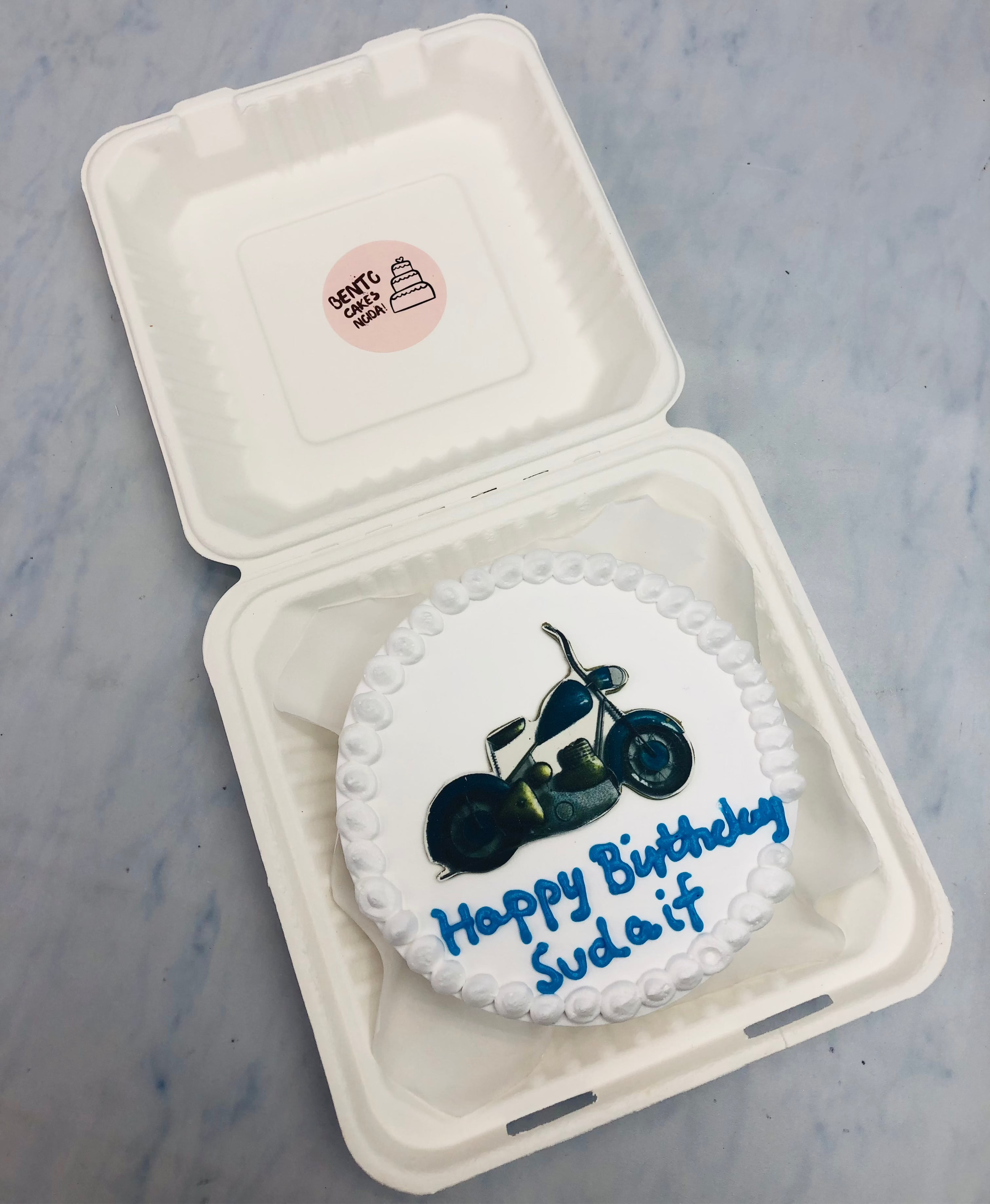 A white bento cake having bullet bike print.