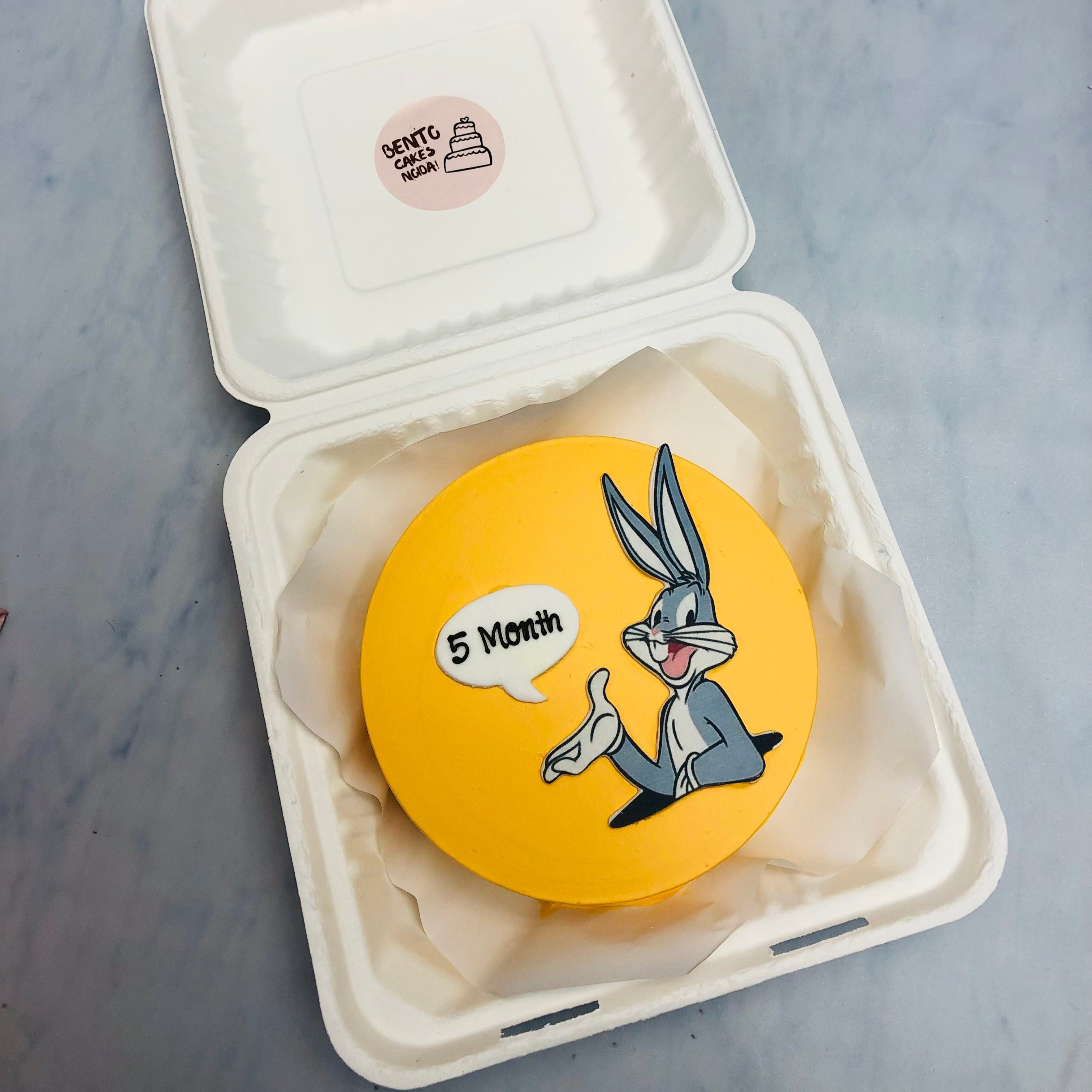 A yellow bento cake with Bunny Bugs cartoon print for 5 months baby.