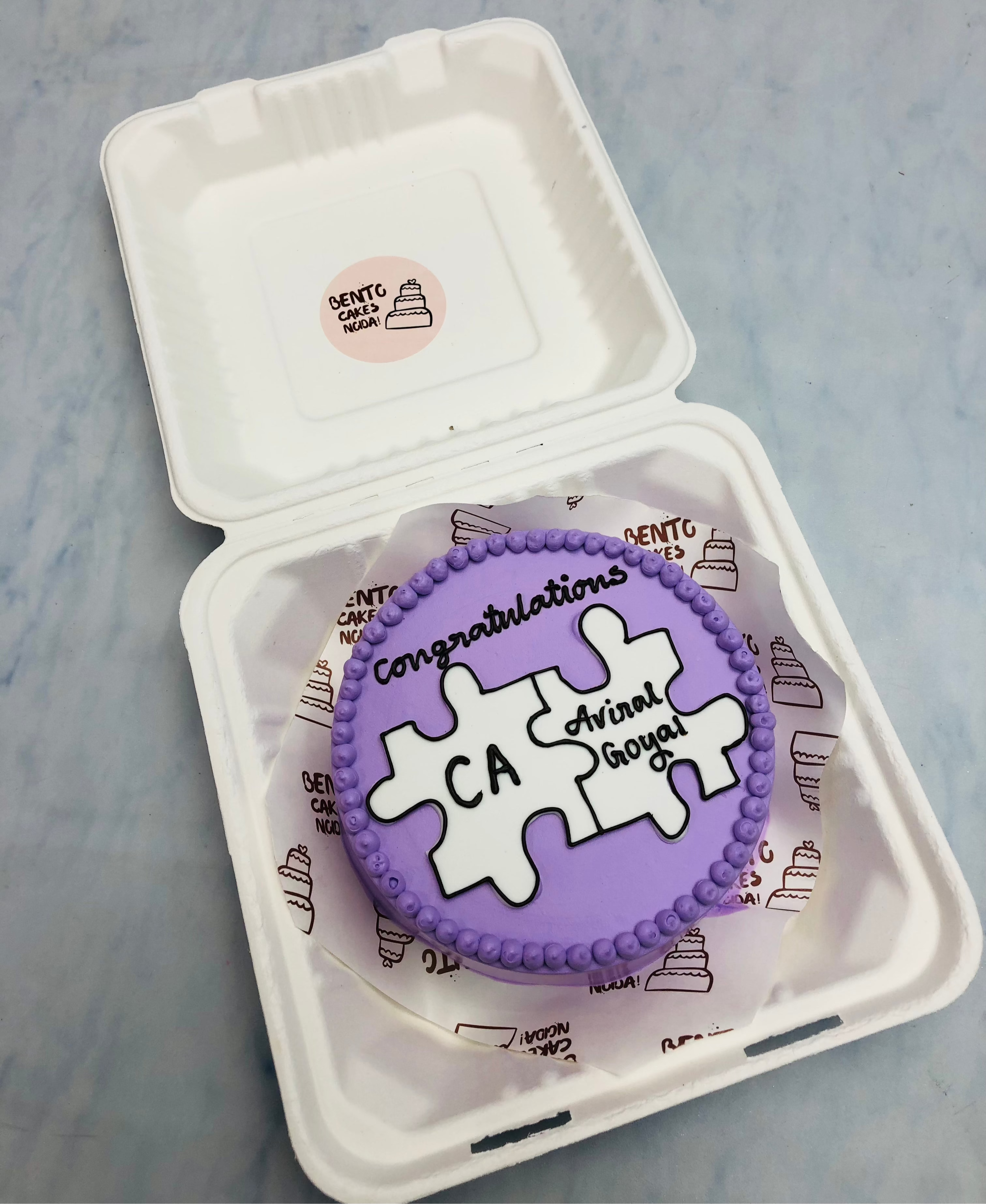 A purple bento cake is designed on puzzle theme for a CA.