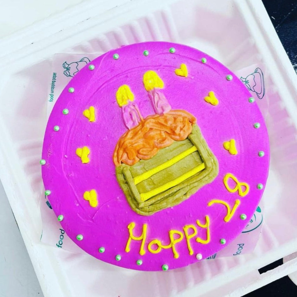 A beautifully decorated birthday cake inside a soft foam container, emphasizing its colorful icing and celebratory theme.