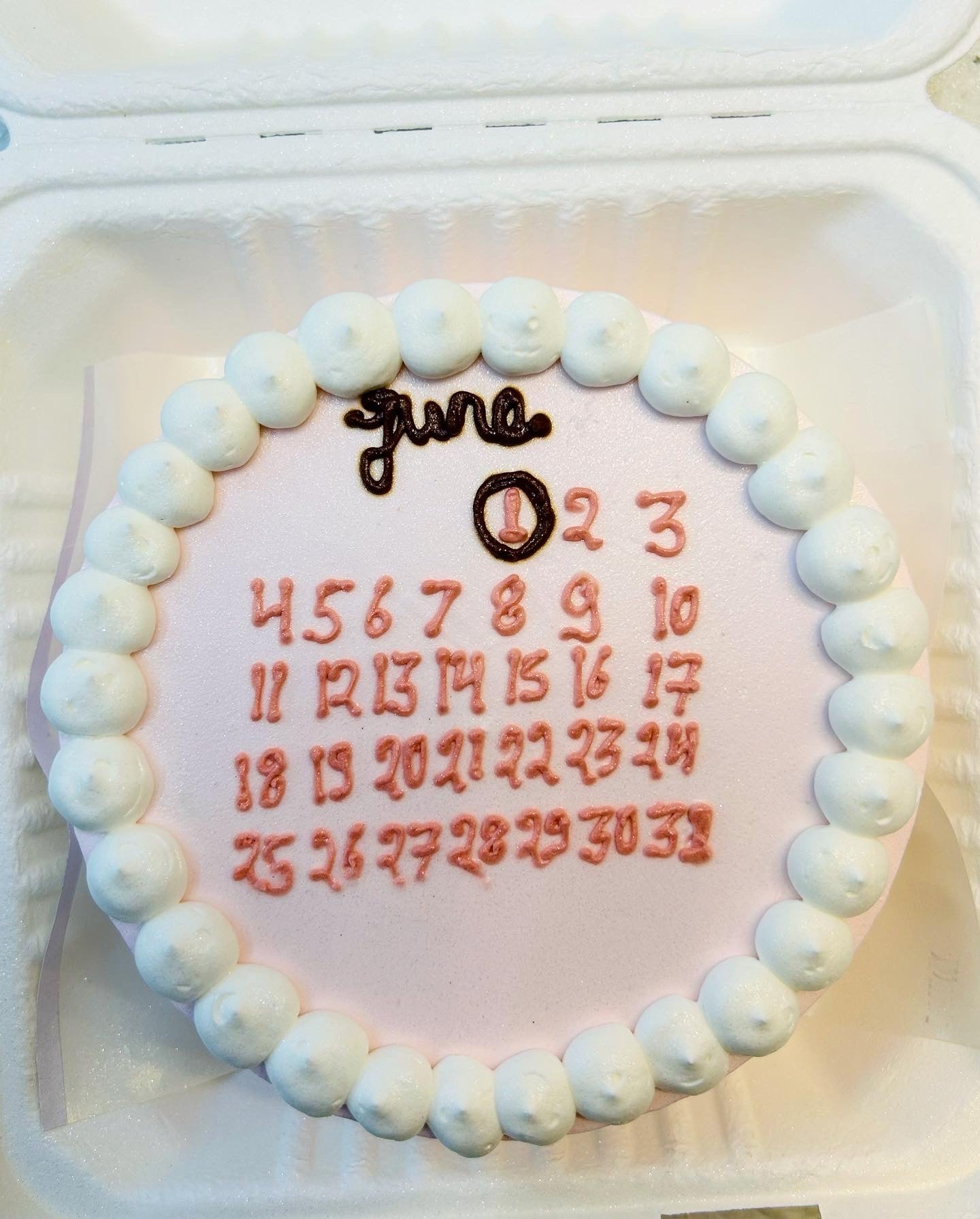 A decorative cake featuring a calendar design on top, symbolizing a special occasion or celebration.