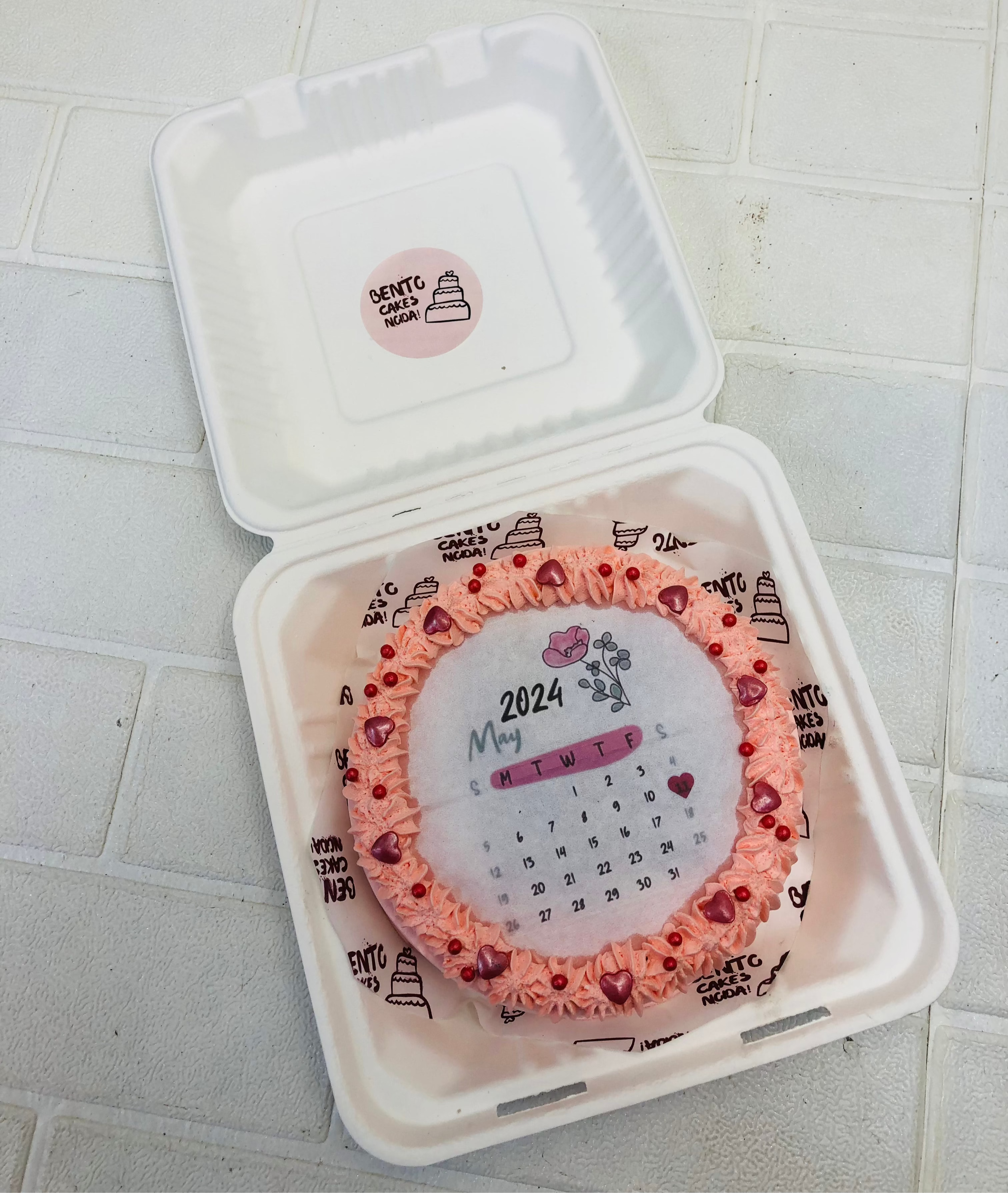 A may calendar theme orange fire bento cake, decorated with red hearts and sprinkles.